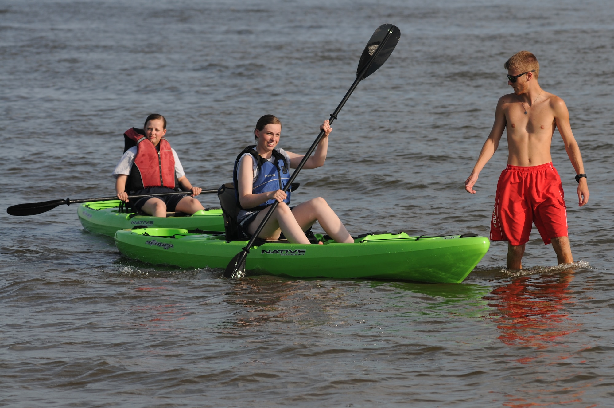 Airmen 1st Class Heather Sargent, 334th Training Squadron, and Stephanie Stansbury, 336th Training Squadron, kayak in the Gulf Coast waters under the watchful eye of Chance Roberts, Keesler lifeguard,  during Keesler’s 4th of July Beach Bash on Biloxi Beach, Miss.  The event included contests, music, games, food and fireworks.  (U.S. Air Force photo by Kemberly Groue)