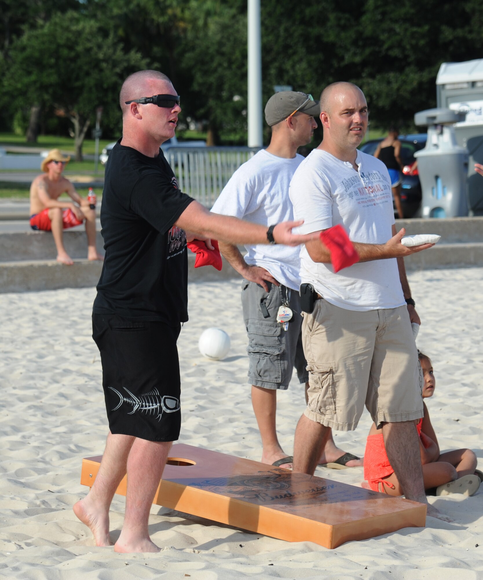 Private 1st Class Matt Allen, Keesler Marine Detachment, tosses a corn bag while Master Sgt. Robert Kesler, 81st Force Support Squadron, waits his turn in a friendly game of corn hole during Keesler’s 4th of July Beach Bash on Biloxi Beach, Miss.  The event included contests, music, games, food and fireworks.  (U.S. Air Force photo by Kemberly Groue)