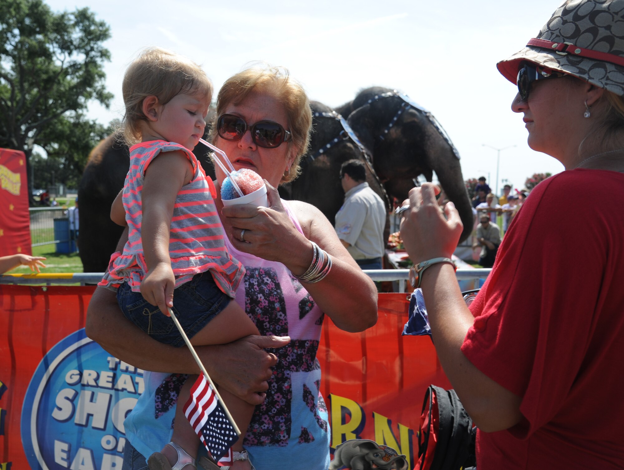 The family of Capt. Tomasz Krygowski, 85th Engineering Installation Squadron, eats snowballs during, “Pachyderm and Popsicles,” hosted by the Ringling Brothers Circus for Keesler deployed families July 3, 2014, at the Mississippi Coast Coliseum.  The Circus also joined with the Keesler Youth Center to present a banner decorated with Keesler kids’ hand prints and an elephant footprint to the Armed Forces Retirement Home July 2. (U.S. Air Force photo by Kemberly Groue)