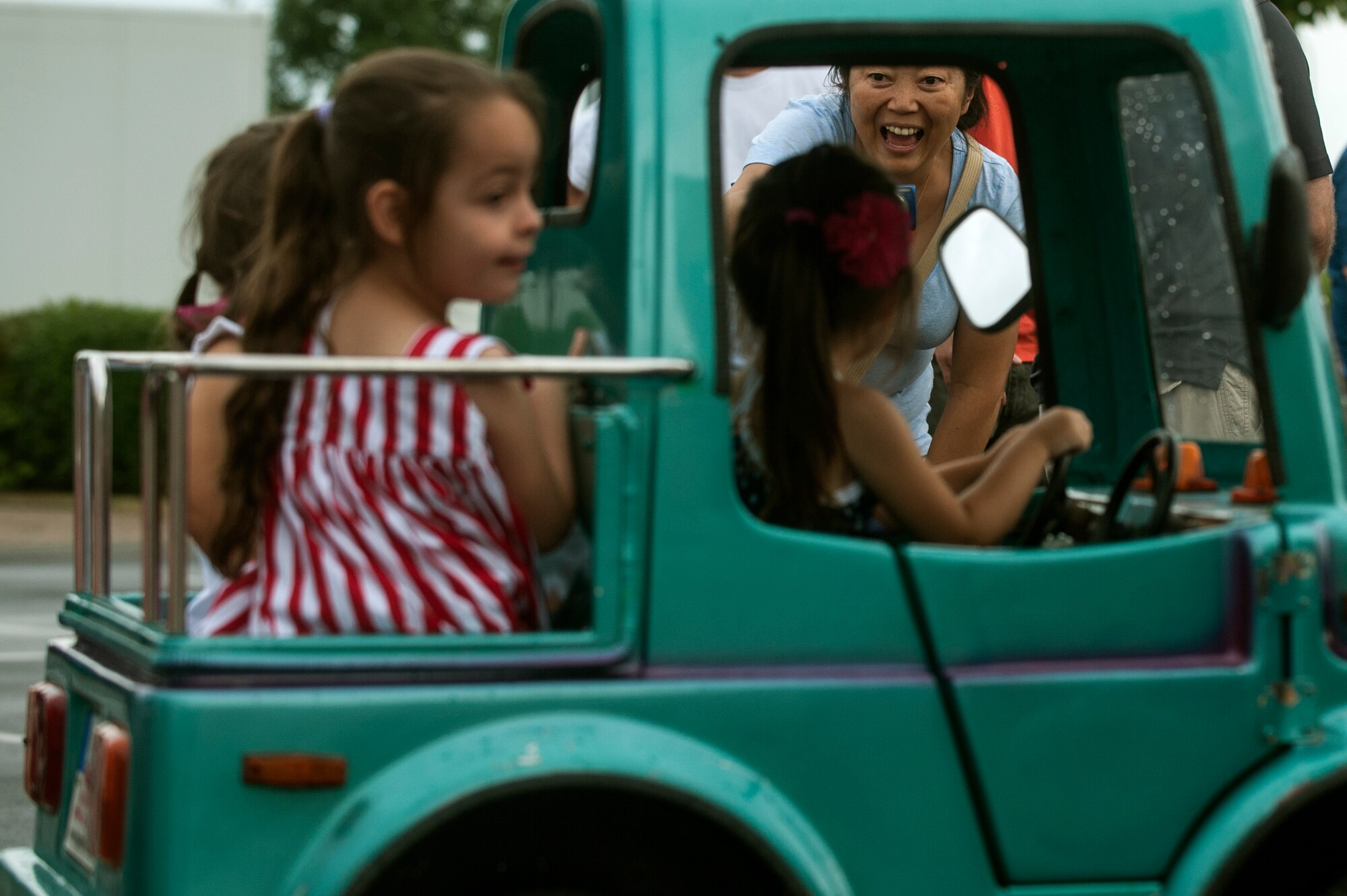 A mom talks to her children as they ride a carousel during the Super Saber Appreciation Day July 4, 2014, at Spangdahlem Air Base, Germany. Event organizers hosted the rides for families as part of the annual Independence Day event.  (U.S. Air Force photo by Senior Airman Rusty Frank/Released)