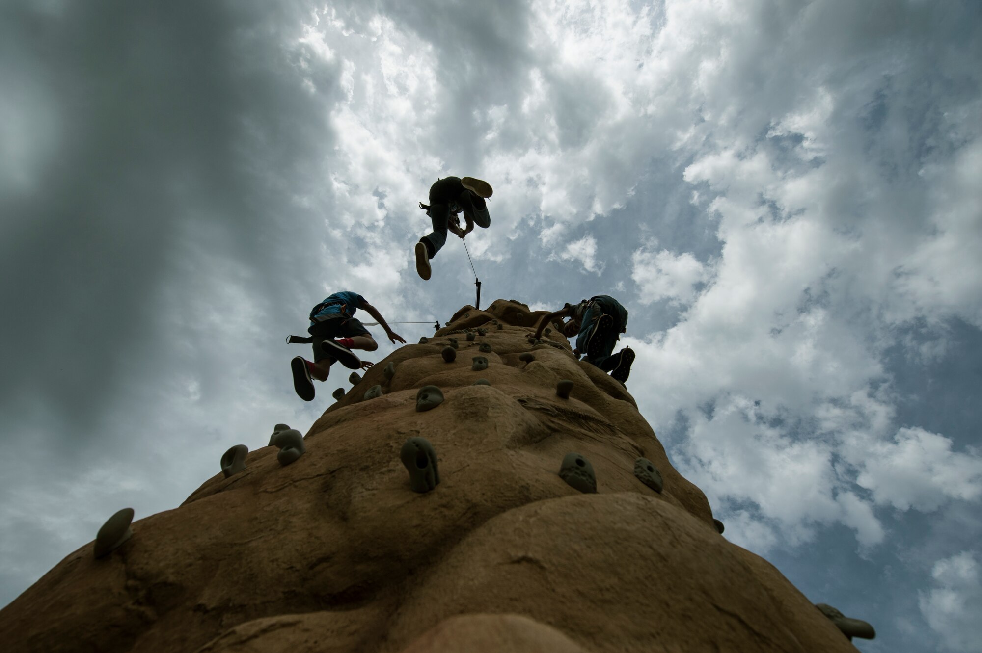 People descend a rock wall during Super Saber Appreciation Day July 4, 2014, at Spangdahlem Air Base, Germany. Families participated in different activities as part of the base’s annual Independence Day celebration. (U.S. Air Force photo by Senior Airman Rusty Frank/Released)