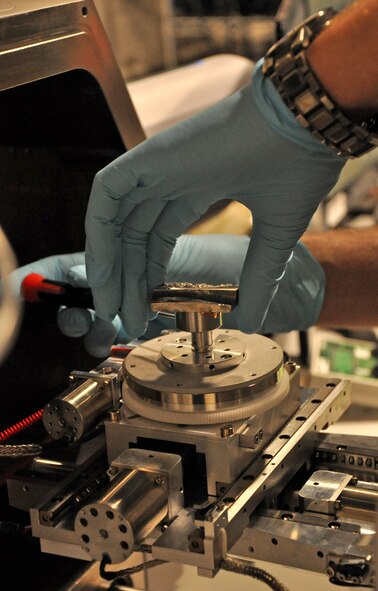 Dr. Adam Pilchak, Air Force Research Laboratory materials research engineer, Wright-Patterson Air Force Base, Ohio, loads a piece of a fractured titanium disk into a scanning electron microscope. By looking at the microscopic features on the fracture surface, researchers are able to determine how the crack initiated and spreads through the component to cause the failure. This helps AFRL researchers identify deficiencies in the manufacturing process and ultimately change the processing route to improve the fatigue capability of future components. "The technology options AFRL provides give our warfighters an advantage on the battlefields of today and tomorrow,” said AFRL commander Maj. Gen. Thomas Masiello. “Those options help ensure we are on the right side of an unfair fight against America's adversaries, and it's our mission to keep it that way.” (Air Force photo by Michele Eaton)