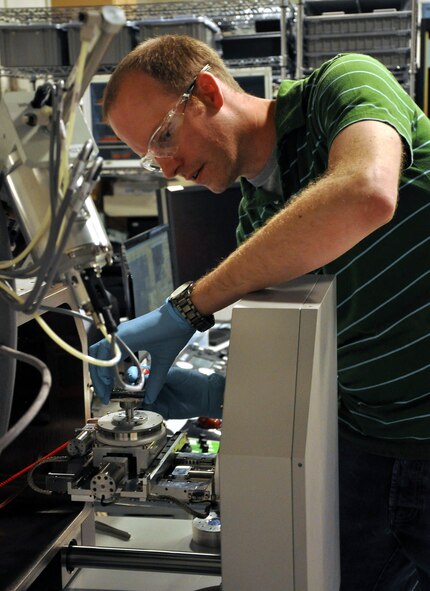 Dr. Adam Pilchak, Air Force Research Laboratory materials research engineer, Wright-Patterson Air Force Base, Ohio, loads a piece of a fractured titanium disk into a scanning electron microscope. By looking at the microscopic features on the fracture surface, researchers are able to determine how the crack initiated and spreads through the component to cause the failure. This helps AFRL researchers identify deficiencies in the manufacturing process and ultimately change the processing route to improve the fatigue capability of future components. "The technology options AFRL provides give our warfighters an advantage on the battlefields of today and tomorrow,” said AFRL commander Maj. Gen. Thomas Masiello. “Those options help ensure we are on the right side of an unfair fight against America's adversaries, and it's our mission to keep it that way.” (Air Force photo by Michele Eaton)