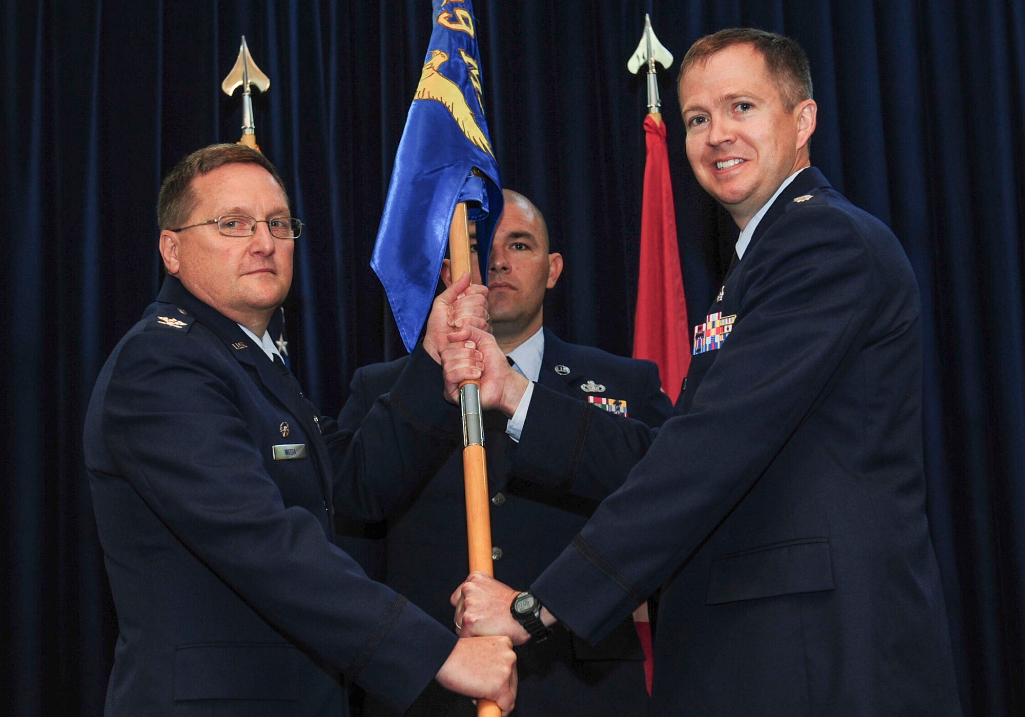 Col. Jerome Wizda, 39th Medical Group commander, passes the guidon to Lt. Col. Jeremy Hooper, 39th Medical Support Squadron incoming commander, during a change of command ceremony July 8, 2014, Incirlik Air Base, Turkey. The ceremony signified the transition of command from Lt. Col. Jonathan Richards to Hooper. (U.S. Air Force photo by Senior Airman Nicole Sikorski/Released)  