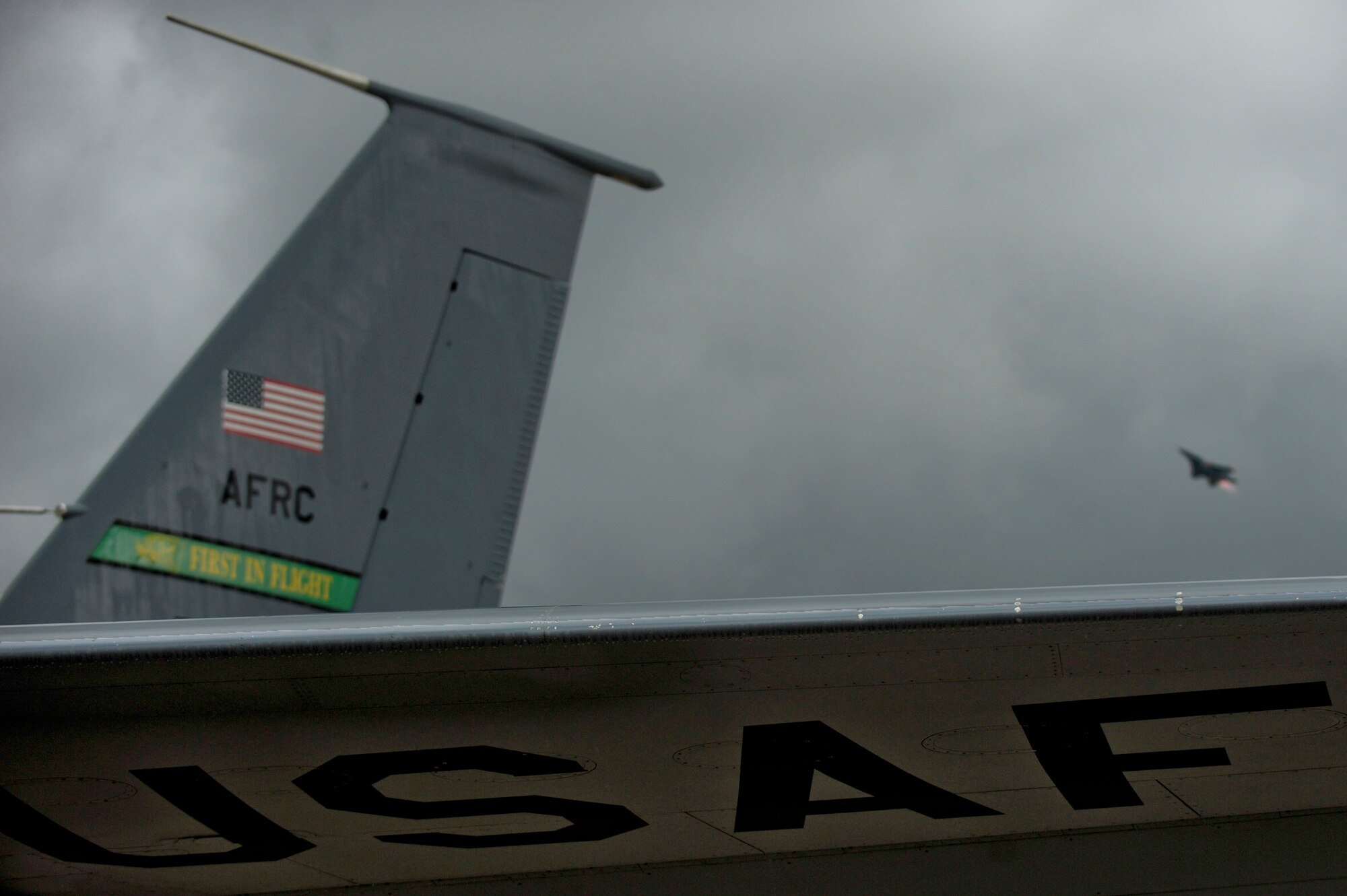 A KC-135R Stratotanker prepares to taxi as an F-15E Strike Eagle takes off in the distance, July 3, 2014 on the flightline at Seymour Johnson Air Force Base, North Carolina. The aircraft were repositioned to Wright-Patterson Air Force Base, Ohio, as a precautionary measure to avoid potential damage from high winds associated with Hurricane Arthur. (U.S. Air Force photo/Airman 1st Class Brittain Crolley)