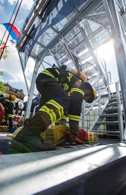 U.S. Air Force Airman 1st Class Scott Weeks, 52nd Civil Engineer Squadron firefighter, from Green Bay, Wis., grasps the fire hose at the sound of the starting whistle during the first Mosel Firefighter Combat Challenge in Ediger-Eller, Germany, July 6, 2014. The obstacle simulates carrying a hose up a burning building to extinguish a fire. (U.S. Air Force photo by Staff Sgt. Christopher Ruano/Released)