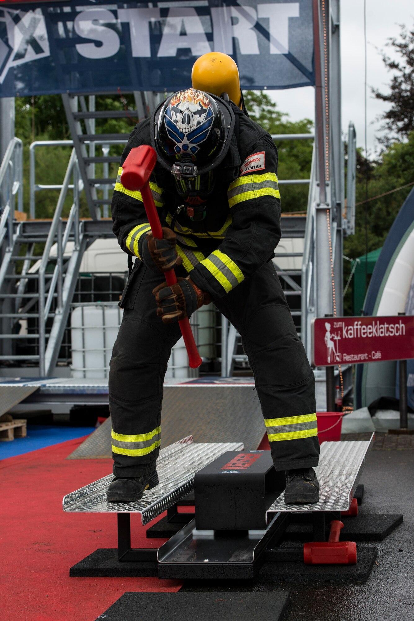 U.S. Air Force Tech. Sgt. James Hickom, Ramstein Air Base, 435th Construction and Training Squadron U.S. Air Forces in Europe and Air Forces Africa fire academy NCO in charge, hammers the Keiser force machine during the first Mosel Firefighter Combat Challenge in Ediger-Eller, Germany, July 5, 2014. The Keiser force machine simulates hammering a hole into a burning building. (U.S. Air Force photo by Staff Sgt. Christopher Ruano/Released)