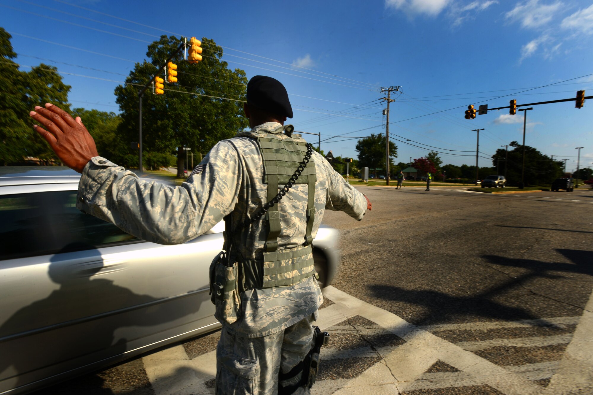 U.S. Air Force Staff Sgt. Gregory Collins, 20th Security Forces Squadron installation patrolman, directs traffic during a base-wide power outage at Shaw Air Force Base, S.C., July 2, 2014. During the approximately 12 hours without power, Shaw was put on critical manning. (U.S. Air Force photo by Airman 1st Class Jensen Stidham/Released)  