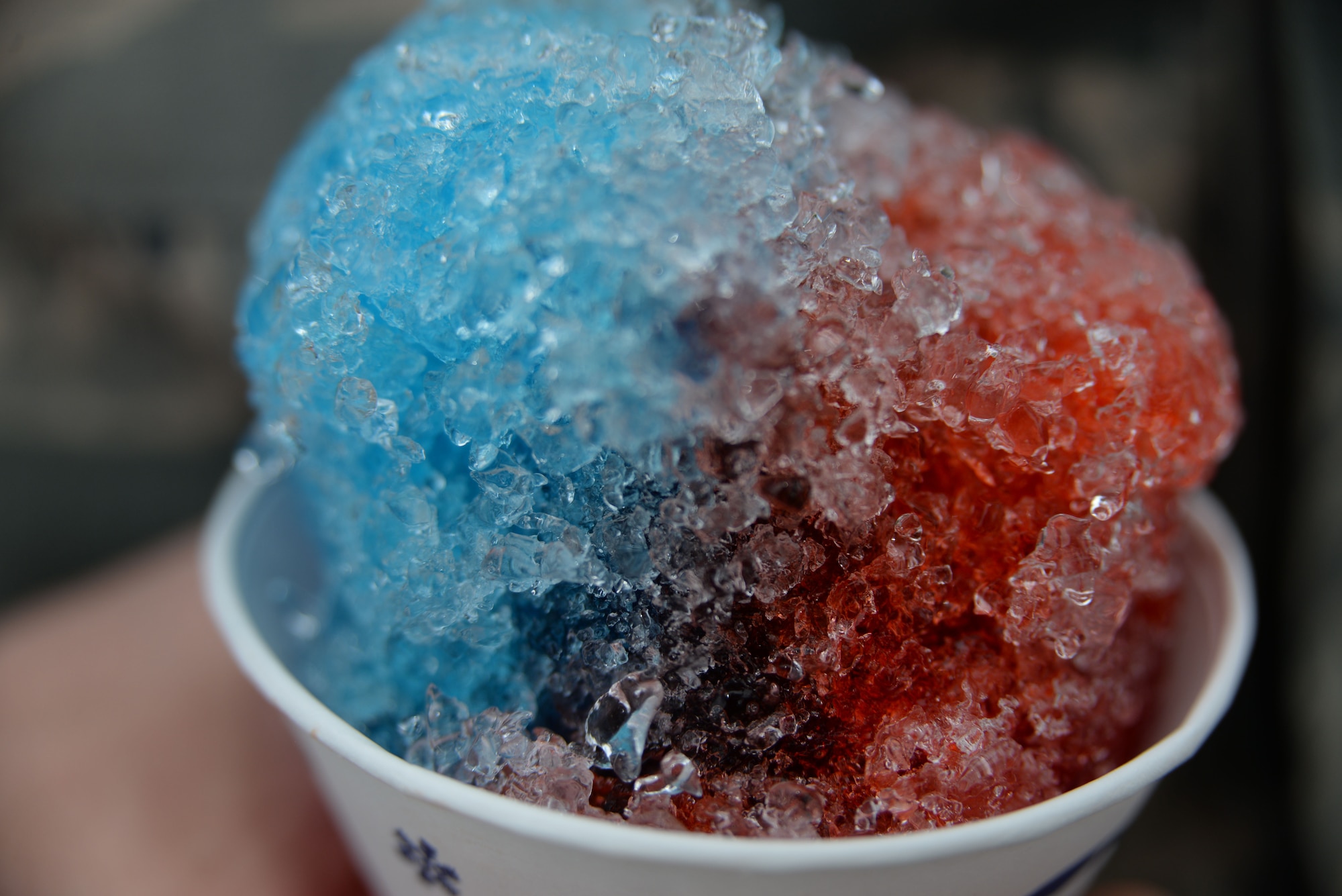 A U.S. Air Force Airman holds a snow cone during the 20th Force Support Squadron Freedom Bash at Shaw Air Force Base, South Carolina, July 3, 2014. The 20th FSS along with members of the sumter community did the event to show their appreciation for service members as well as to celebrate the Fourth of July. (U.S. Air Force photo by Airman 1st Class Michael A. Cossaboom/Released)