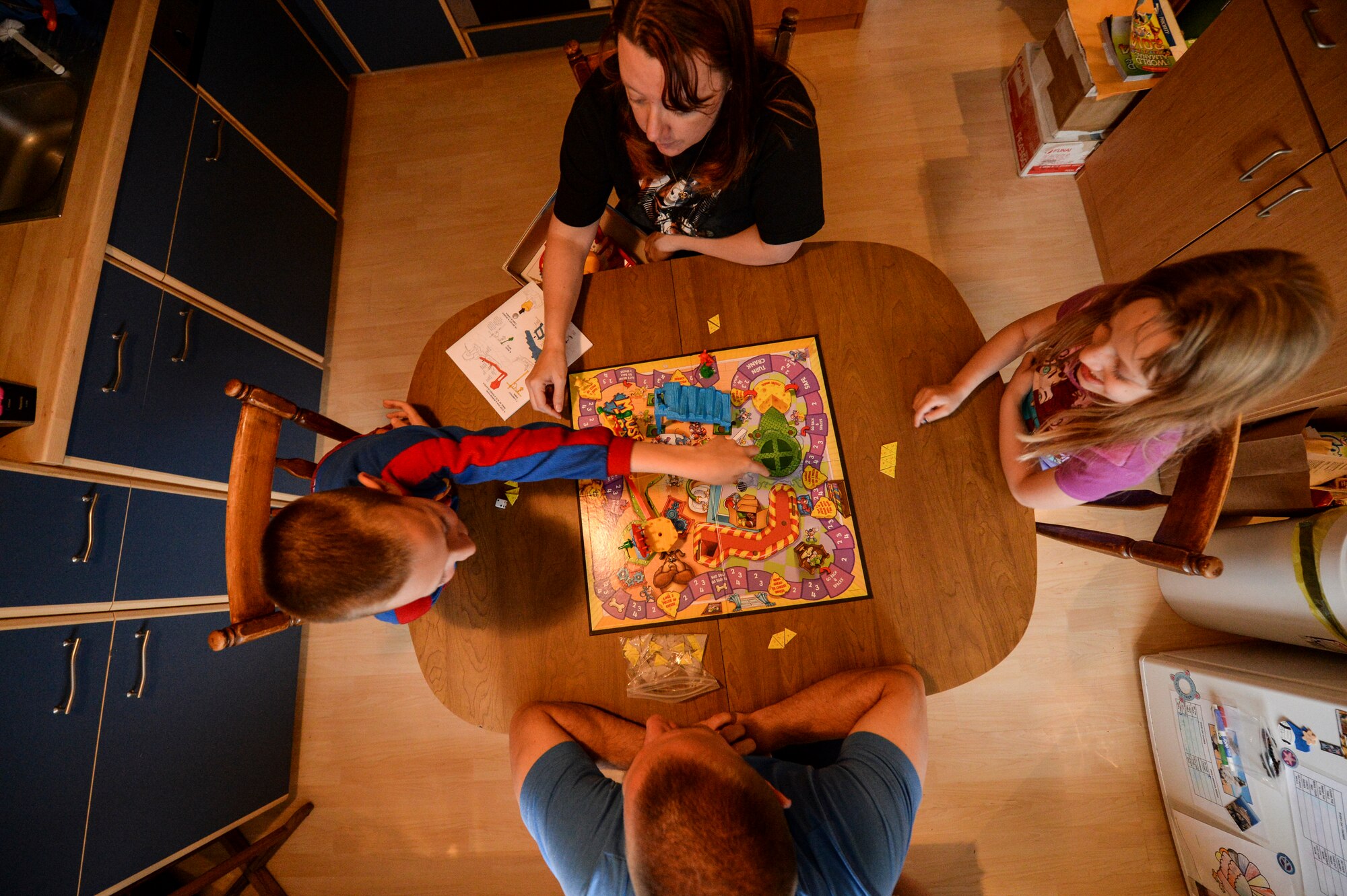 U.S. Air Force Master Sgt. Donald Stichter, 52nd Equipment Maintenance Squadron NCO in charge of munitions inspection from Lakewood, Colo., plays a board game with his family May 5, 2014 at his house in Malbergwelch, Germany. Stichter credits his family’s love and support to his success while training and competing in his first marathon. (U.S. Air Force photo by Senior Airman Rusty Frank/Released)