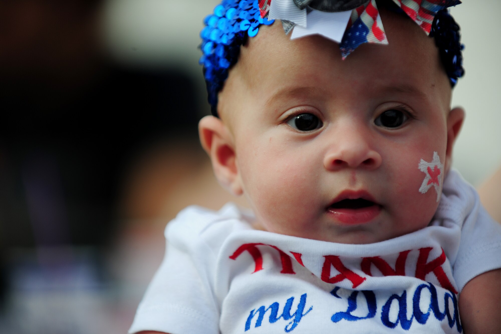 A baby enjoys her first Fourth of July celebration, after getting her face painted at RAF Alconbury, United Kingdom, July 3, 2014. Children and adults were able to come together and enjoy the Independence Day celebration. (U.S. Air Force photo by Staff Sgt. Jarad A. Denton/Released)