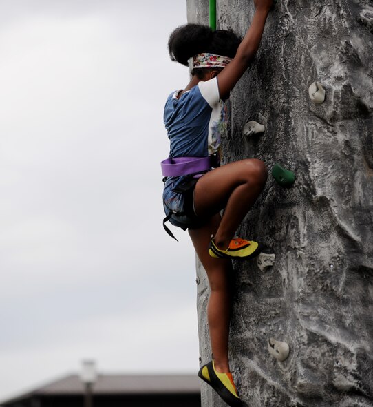 A young girl climbs an artificial rock wall during the Fourth of July celebration on RAF Alconbury, United Kingdom, July 3, 2014. During the celebration, patrons were able to enjoy food, games, music and rides. (U.S. Air Force photo by Staff Sgt. Jarad A. Denton/Released)