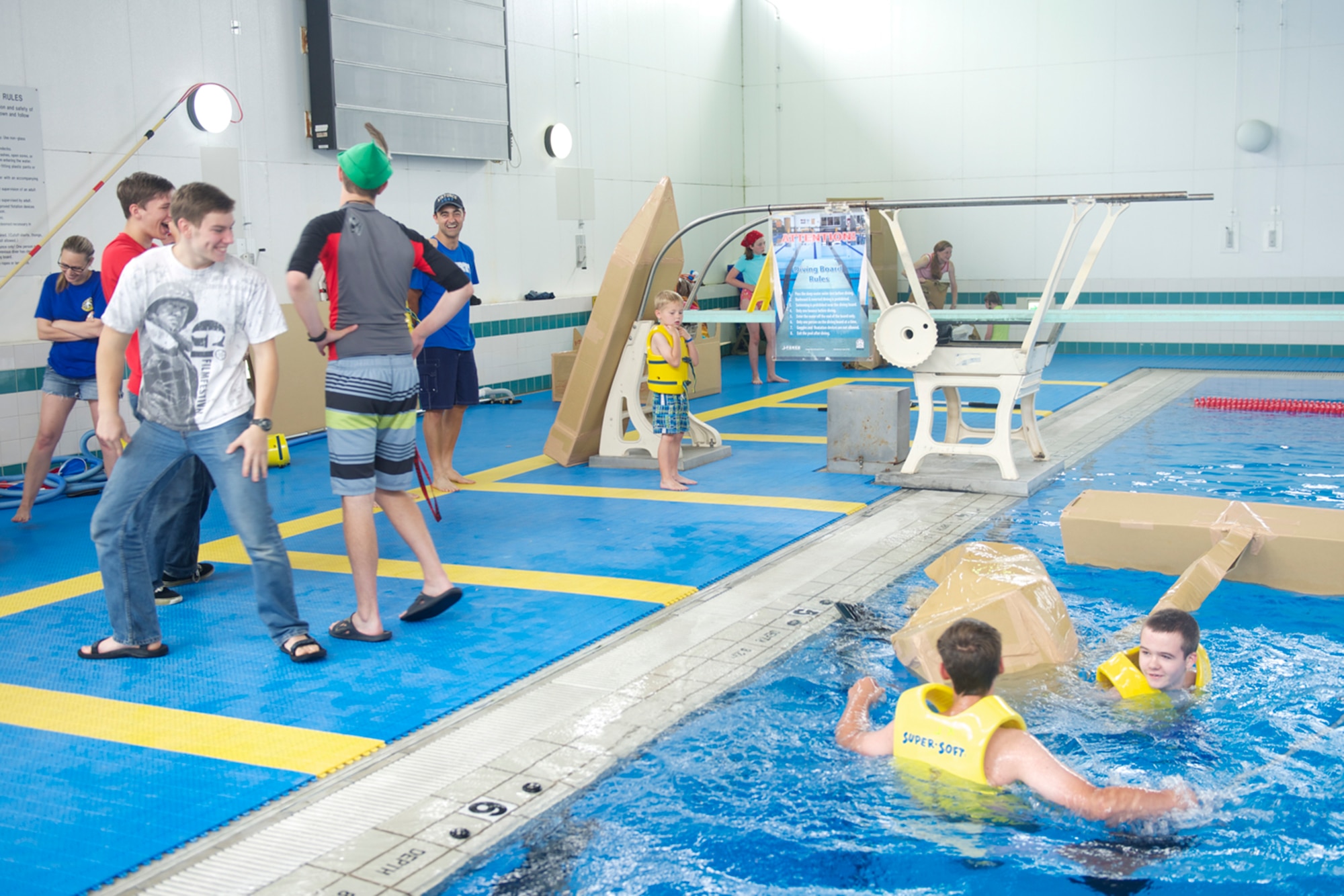 Teammates laugh as their cardboard boat sinks at the starting line during the Leaky Kon Tiki race at Yokota Air Base, Japan, July 4, 2014. The 374th Force Support Squadron hosted the event as part of Celebrate America. (U.S. Air Force photo by Airman 1st Class David Danford/Released)