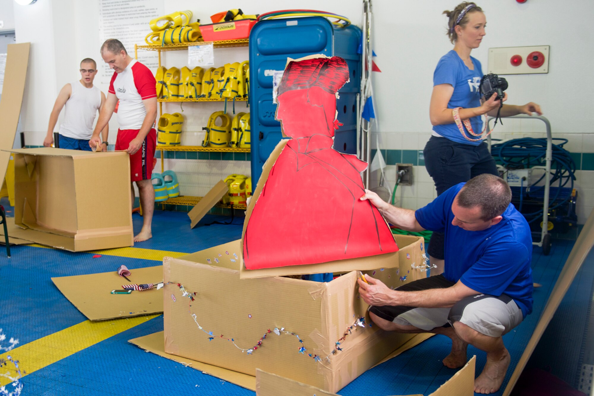 Families work together to build cardboard boats for the Leaky Kon Tiki race during the Celebrate America event at Yokota Air Base, Japan, July 4, 2014. In addition to the race, the 374th Force Support Squadron hosted events throughout the day to include a 5k Fun Run, go-karts, carnival booths and performances from the Band of the Pacific-Asia Pacific Trends and the Bon Jovi tribute band, Slippery When Wet. (U.S. Air Force photo by Airman 1st Class David Danford/Released)