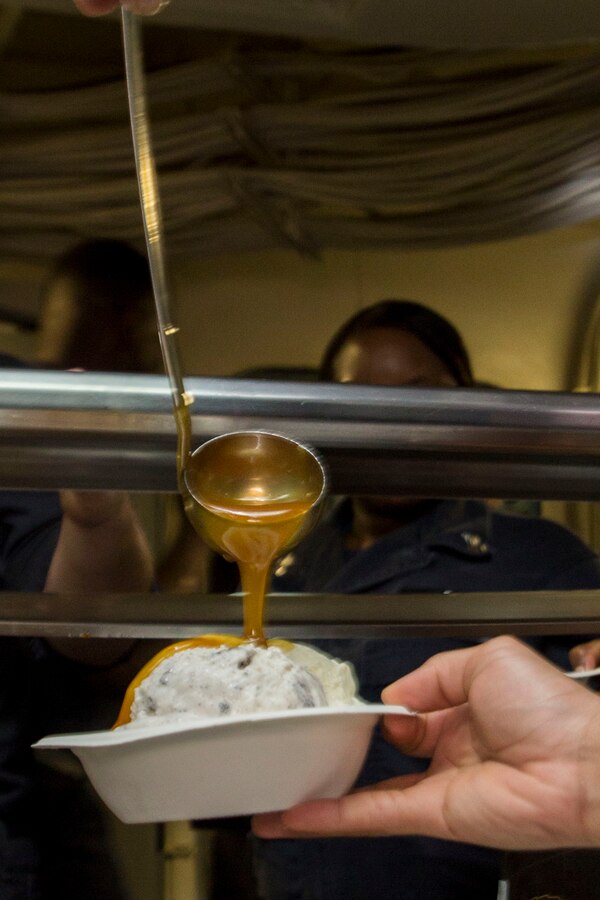 U.S. 5TH FLEET AREA OF RESPONSIBILITY (July 5, 2014) A U.S. Navy Sailor with the amphibious transport dock ship USS Mesa Verde (LPD 19) pours butterscotch onto ice cream during an ice cream social. The 22nd MEU is deployed with the Bataan Amphibious Ready Group as a theater reserve and crisis response force throughout U.S. Central Command and the U.S. 5th Fleet area of responsibility. (U.S. Marine Corps photo by Cpl. Manuel A. Estrada/Released)