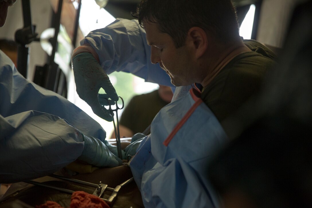 Lt. Cmdr. Joseph Fitzpatrick, a Forward Resuscitative Surgical System team member with 2nd Medical Battalion, 2nd Marine Logistics Group treats a simulated casualty wearing a CutSuit, a hyper-realistic surgical simulator that mimics the inside and outside of the human body, during a training scenario at Camp Lejeune, N.C, June 28, 2014. Service members with mock injuries helped increase the realism of the training as the unit prepared for possible casualty scenarios