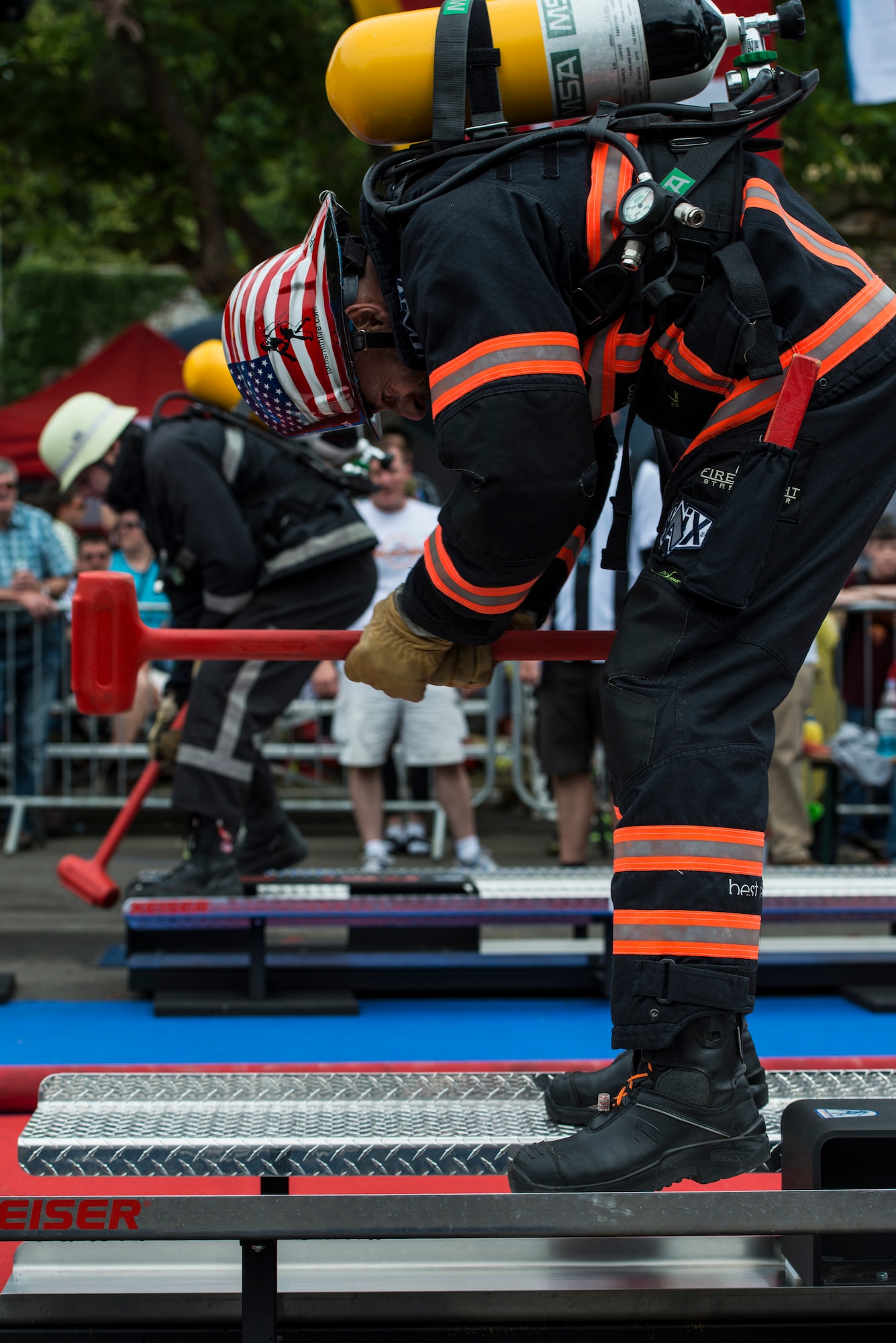 Gerd Mueller hammers the Keiser force machine during the first Mosel Firefighter Combat Challenge July 5, 2014, in Ediger-Eller, Germany. The Keiser force machine simulates hammering a hole into a burning building. Mueller is a 52nd Civil Engineer Squadron firefighter crew chief and a native of Gransdorf, Germany. (U.S. Air Force photo/Staff Sgt. Christopher Ruano)