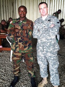 Michigan National Guard Sgt. Matthew Robinson and Liberian Armed Forces soldier Pvt. 1st Class Musa Jabateh pose for a picture during a training exercise at Edward B. Kesselly Barracks in Monrovia, Liberia, June 12, 2014. 