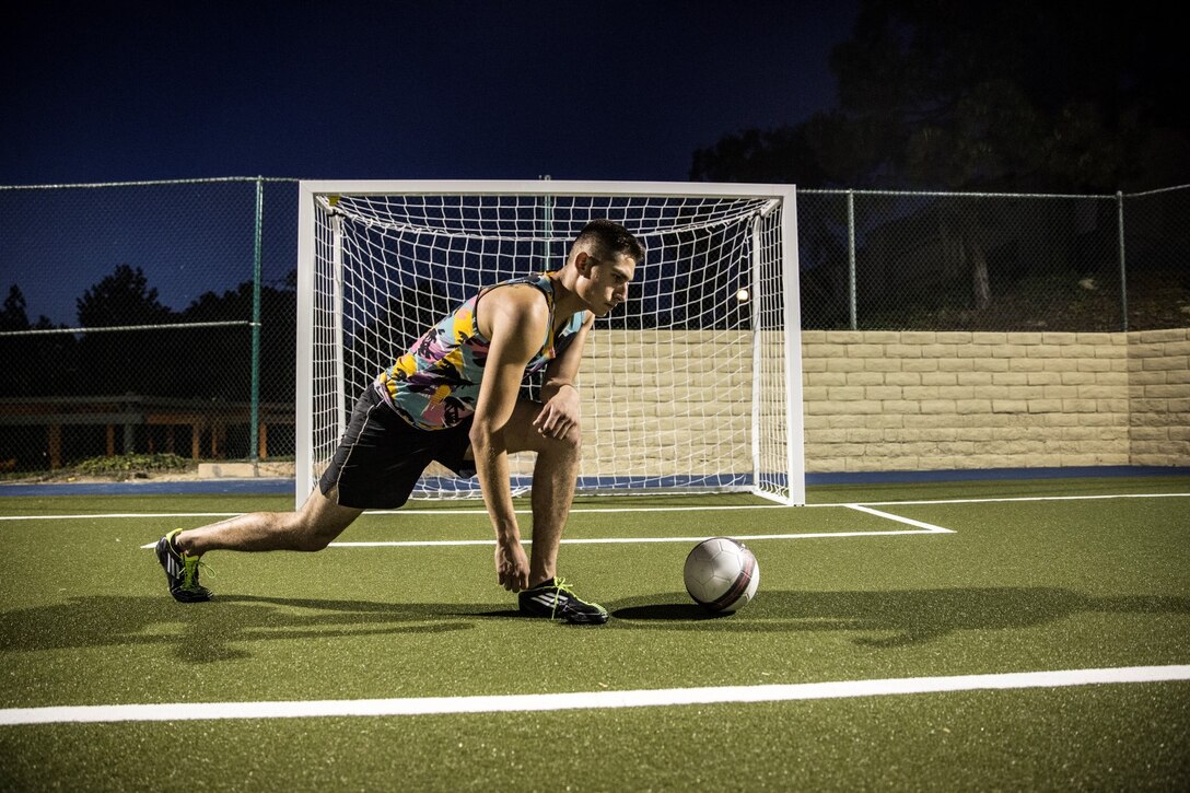 Corporal Rene Gonzalez, data network specialist, 15th Marine Expeditionary Unit, stretches before sharpening his skills as a soccer player in Oceanside, Calif., July 7, 2014. Gonzalez, 21, is from Joliet, Illinois, and is stationed aboard Camp Pendleton, Calif. (U.S. Marine Corps photo by Cpl. Emmanuel Ramos/Released)