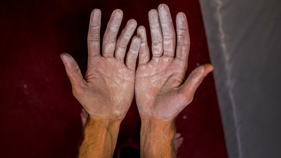 Corporal Tyler Bukoski, computer maintainer, 15th Marine Expeditionary Unit, demonstrates his hands to another climber at a rock climbing gym in Carlsbad, Calif., June 27, 2014. Bukoski, 22, is from Wanaque, New Jersey. (U.S. Marine Corps photo by Cpl. Emmanuel Ramos/Released)