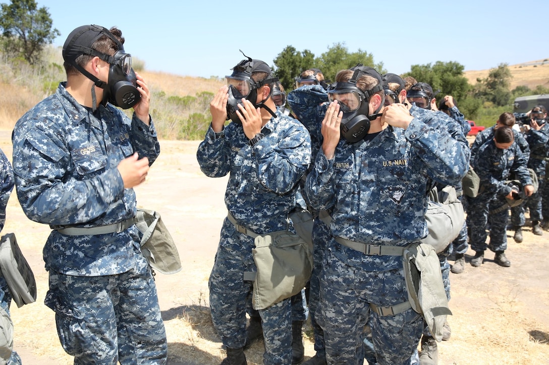 Midshipmen with 1st Platoon, 2nd Block, Company F, check each other's gas masks before entering the gas chamber during Professional Training for Midshipmen Marine Week aboard Marine Corps Base Camp Pendleton, Calif., July 1, 2014. The PROTRAMID program allows midshipmen to rotate through four week-long evolutions with each different service community in the Navy during their sophomore summer at the Naval Academy. At the beginning of their senior year, they will rank their preferences of which community they'd like to join before being placed based on the needs of the Navy and the Marine Corps. (U.S. Marine Corps photo by Cpl. Anna Albrecht)