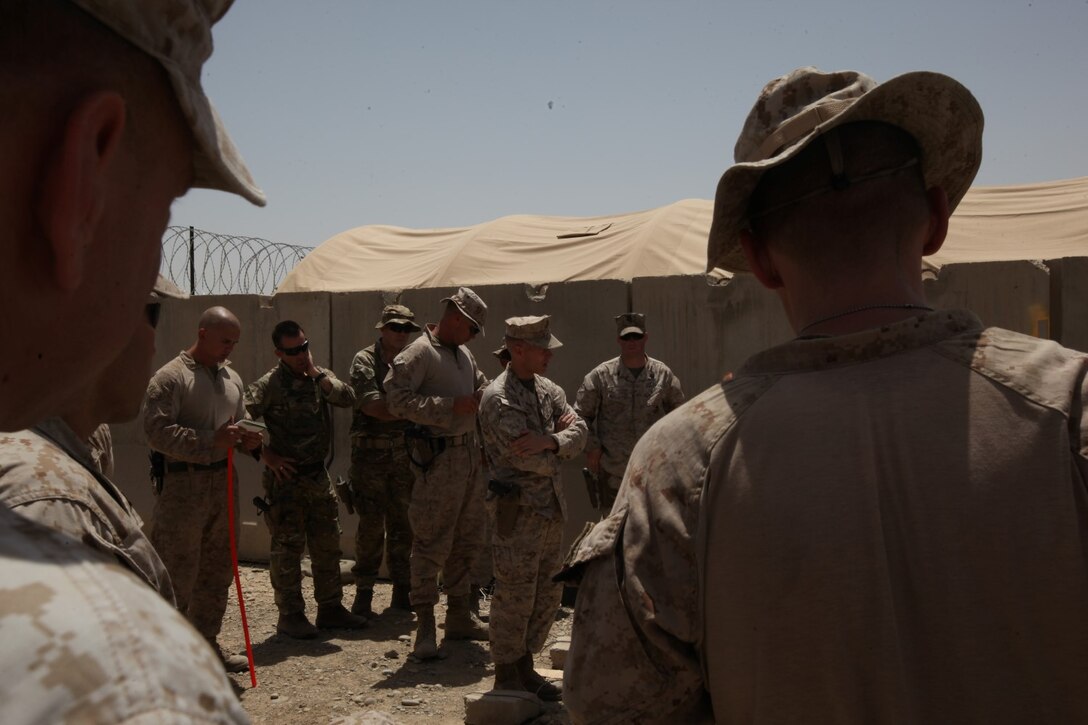 Colonel William McCollough, center, Afghan National Police Advisor Team officer in charge, speaks to his and Combat Logistics Battalion 7's Marines and sailors during their final brief aboard Patrol Base Dimond, Helmand province, Afghanistan, June 26, 2014. The Marines and sailors of the ANPAT completed their eight-month deployment of advising the Afghan National Police to develop a strong, capable and credible police force for Helmand province. The ANPAT,Äôs retrograde back to Camp Leatherneck, Afghanistan, was assisted by the Marines and sailors of Combat Logistics Battalion 7. (U.S. Marine Corps Photo By: Sgt. Frances Johnson)