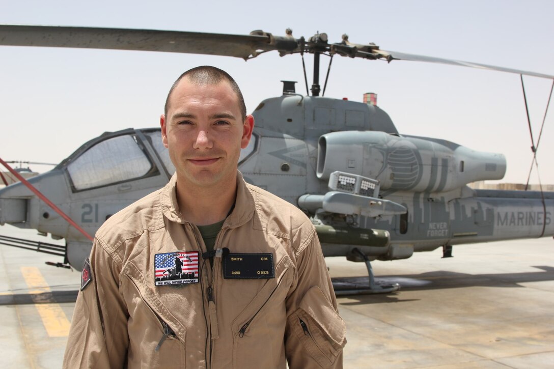 U.S. Marine Capt. Christopher Smith, a native of Lake Worth, Florida and pilot with Marine Light Attack Helicopter Squadron 467, stands next to a AH-1W Super Cobra helicopter before a mission on the Fourth of July. Smith and U.S. service members throughout Regional Command (Southwest) gathered with their units to honor Independence Day while deployed to Afghanistan, July 4, 2014.