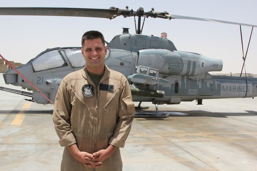 U.S. Marine Lance Cpl. Micah Musso, a native of Baton Rouge, Louisiana, and crew chief with Marine Light Attack Helicopter Squadron 467, stands next to a Super Cobra helicopter before a mission on the Fourth of July. U.S. service members throughout Regional Command (Southwest) gathered with their units to honor Independence Day while deployed to Afghanistan, July 4, 2014.