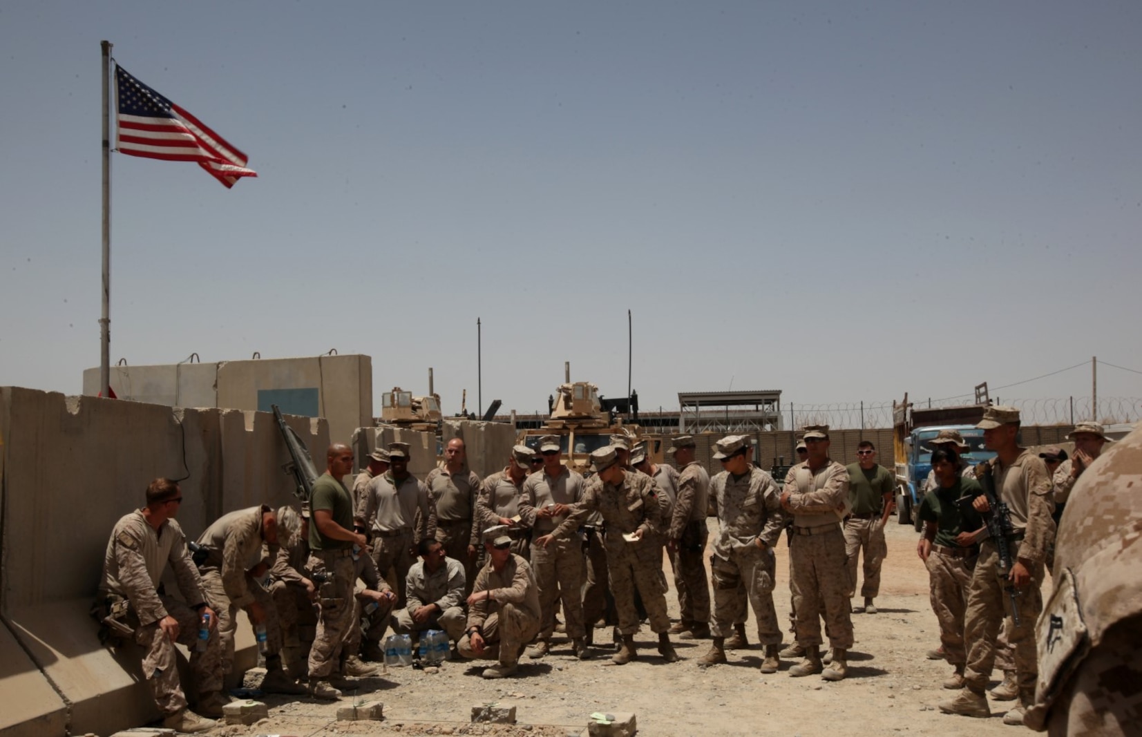 Marines and sailors with the Afghan National Police Advisor Team and Combat Logistics Battalion 7 wait for their final brief to start aboard Patrol Base Dimond, Helmand province, Afghanistan, June 26, 2014. The Marines and sailors of the ANPAT completed their eight-month deployment of advising the Afghan National Police to develop a strong, capable and credible police force for Helmand province. The ANPAT's retrograde back to Camp Leatherneck, Afghanistan, was assisted by the Marines and sailors of Combat Logistics Battalion 7. (U.S. Marine Corps Photo By: Sgt. Frances Johnson)