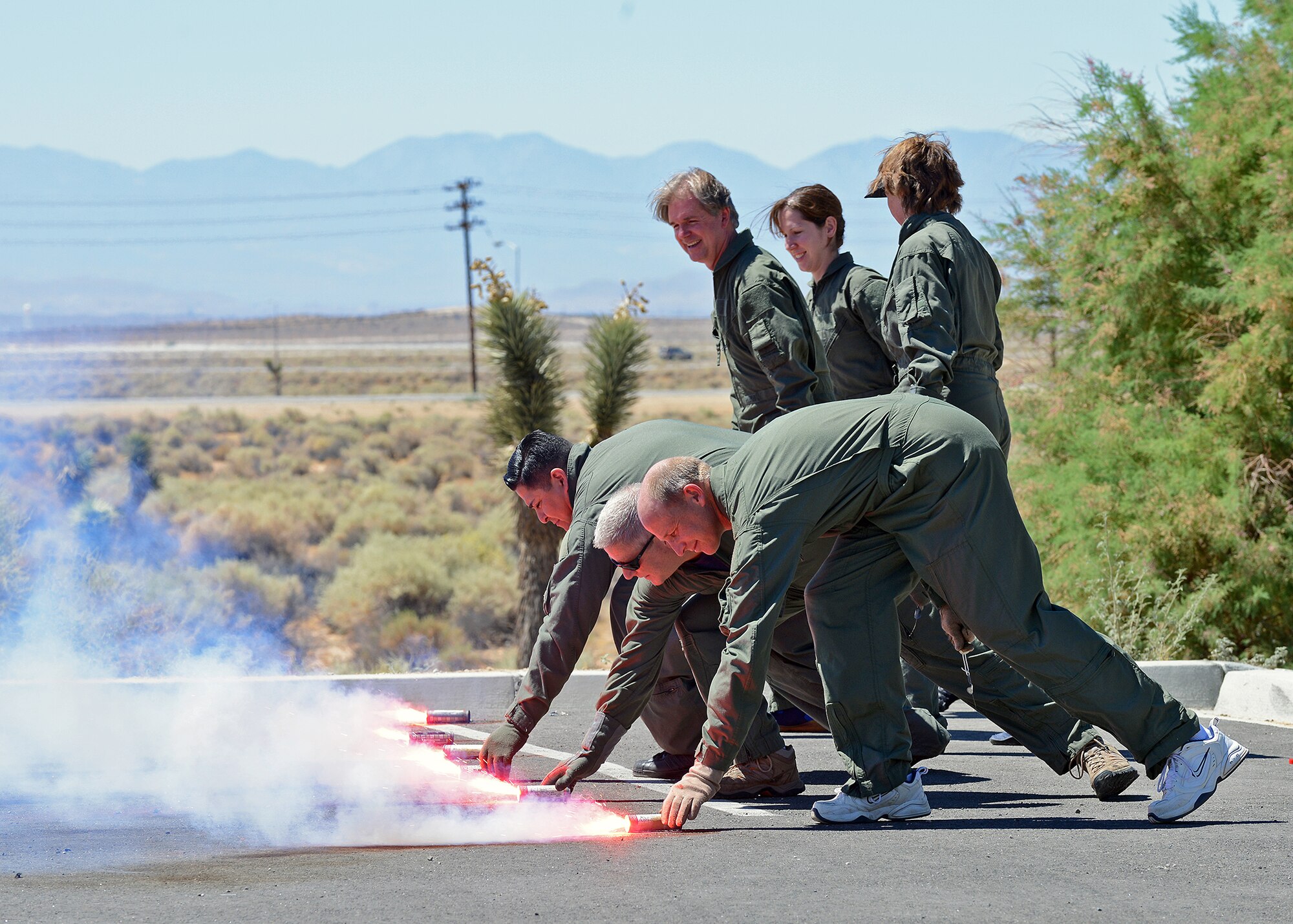 A group of honorary commanders and their guests set off smoke and flare canisters with the help of Edwards Survival, Evasion, Resistance, and Escape instructors July 2 during a land and water survival training class at the Oasis Aquatic Center. The primary objective of the Honorary Commanders Program is to familiarize community leaders with Edwards' operations by pairing them with unit commanders and directors at both social and official functions. This program is an avenue for community partner leaders to learn about the Air Force mission, personnel, programs and operations. (U.S. Air Force photo by Jet Fabara)