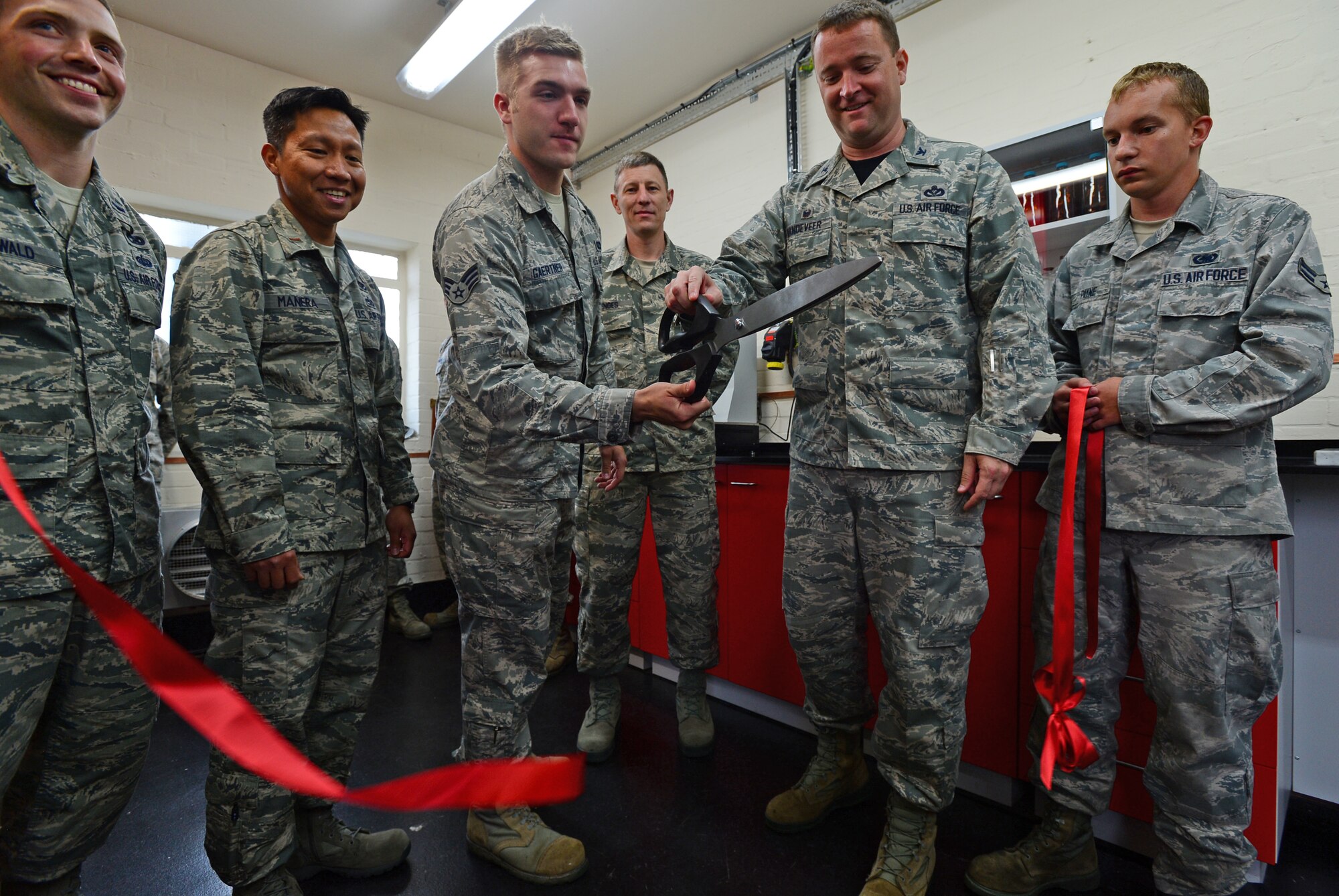 Col. Marc Vandeveer, 48th Mission Support Group commander, participates in a ribbon-cutting ceremony at the 48th Logistics Readiness Squadron fuels management flight at Royal Air Force Lakenheath, England, June 27, 2014. The 48th Civil Engineer Squadron coordinated with the 48th LRS to complete a two-year-long laboratory project that allows the FMF to analyze the installation’s ground and aviation fuel at a fraction of the time and cost. (U.S. Air Force photo by Airman 1st Class Erin O’Shea/Released) 