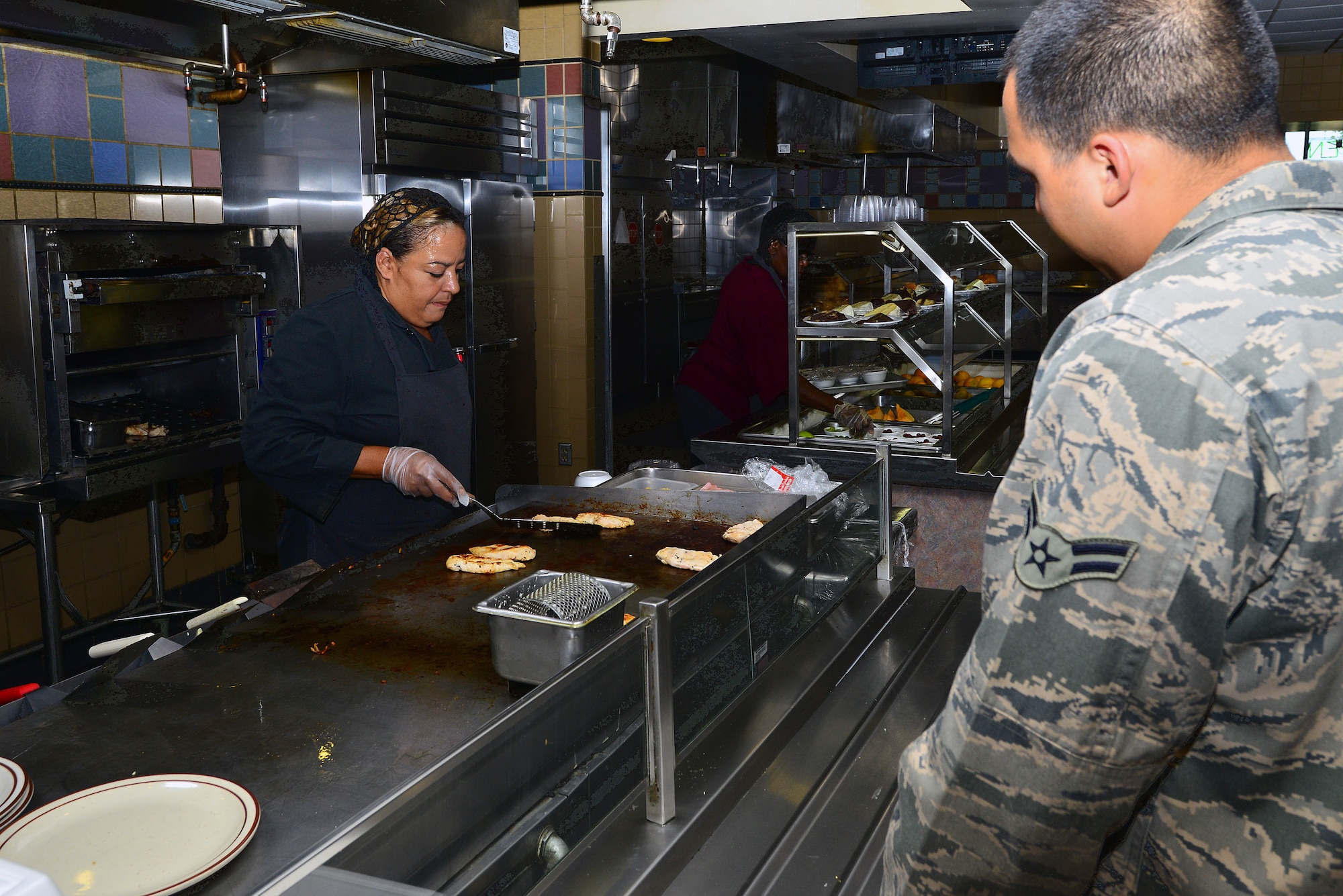 Brenda Russell, 22nd Force Support Squadron chef, works the grill at the Chisholm Trail Dining Facility, July 9, 2014, at McConnell Air Force Base, Kan. The DFAC is available to active duty, reserve, and guard Airmen for four meals a day, seven days a week. (U.S. Air Force photo/Senior Airman Trevor Rhynes)