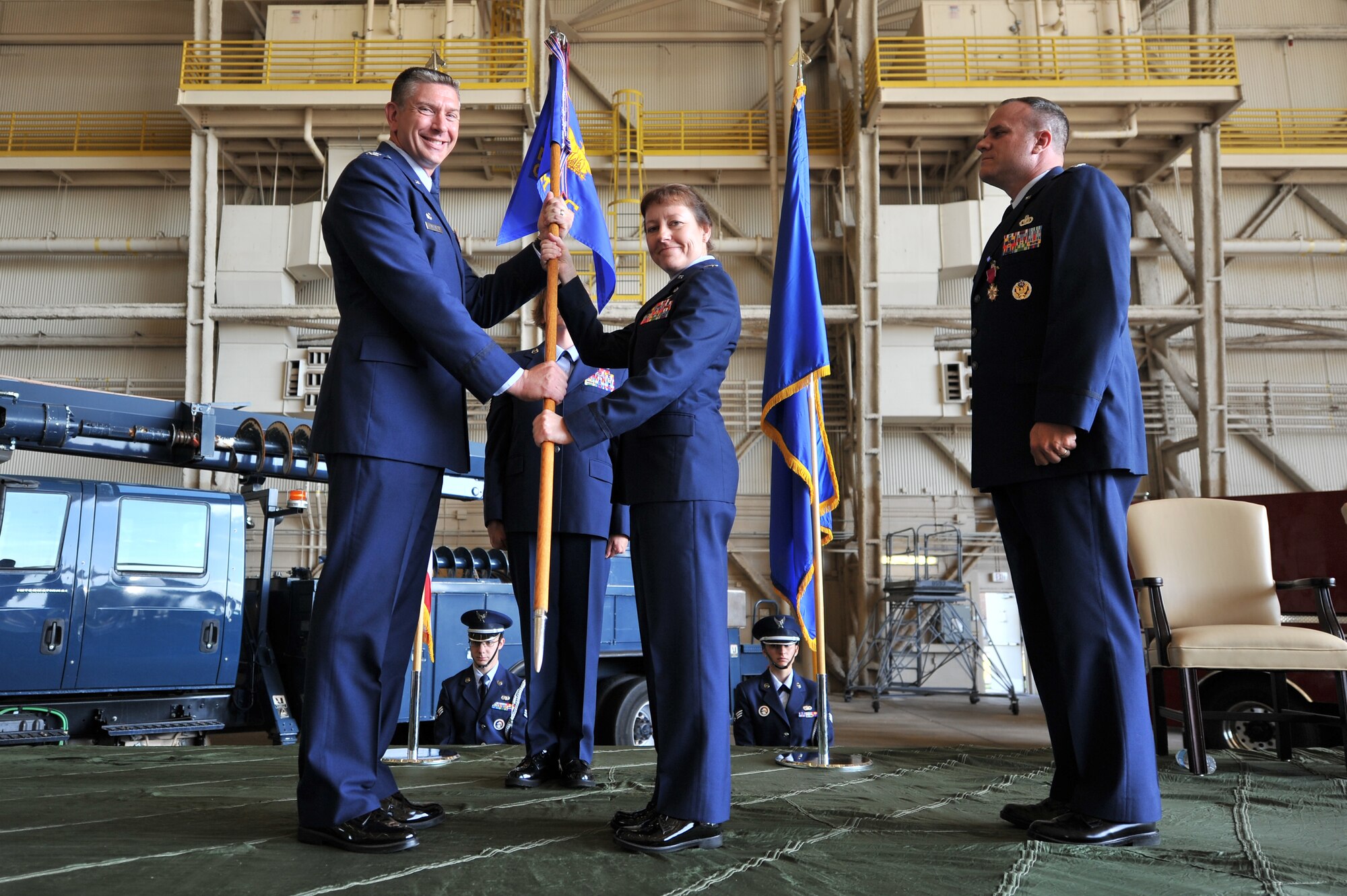 ALTUS AIR FORCE BASE, Okla. – U.S. Air Force Col. Bill Spangenthal, 97th Air Mobility Wing commander, passes command of the 97th Mission Support Group from U.S. Air Force Col. Michael Greiner, 97th MSG outgoing commander, to U.S. Air Force Lt. Col. Terri Jones, 97th MSG incoming commander, during the 97th MSG change of command ceremony inside Hangar 517 July 9, 2014. The ceremony allowed Jones and Greiner to address the members in attendance and offer reassurance that the group will continue to provide first class support for the mission as well as Airmen and their families. (U.S. Air Force photo by Senior Airman Dillon Davis / Released)