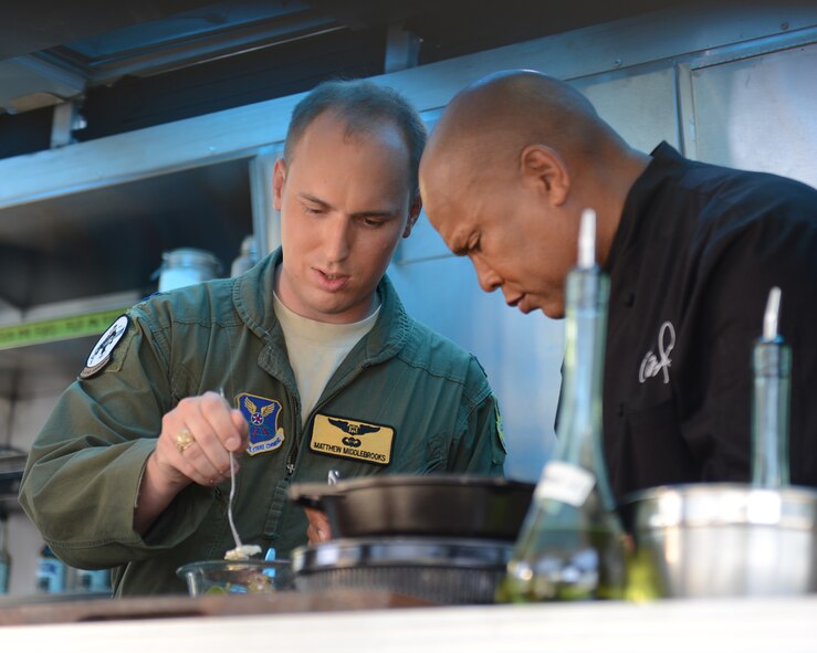 Capt. Matthew Middlebrooks, 11th Bomb Squadron, prepares to taste a salad with Chef Jeff Henderson, Flip My Food host, on Barksdale Air Force Base, La., July 9, 2014. Henderson cooked various healthy dishes for Barksdale Airmen. (U.S. Air Force photo/Senior Airman Benjamin Gonsier)