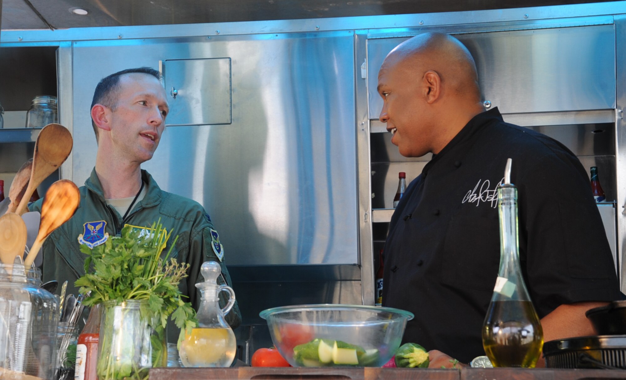 Col. Leland Bohannon, 2nd Bomb Wing vice commander, talks with  Chef Jeff Henderson, Flip My Food host, on Barksdale Air Force Base, La., July 9, 2014. Chef Jeff Henderson, Flip My Food host, takes traditional recipes and flips them into fresh, healthy dishes.  (U.S. Air Force photo/Staff Sgt. Sean Martin)


