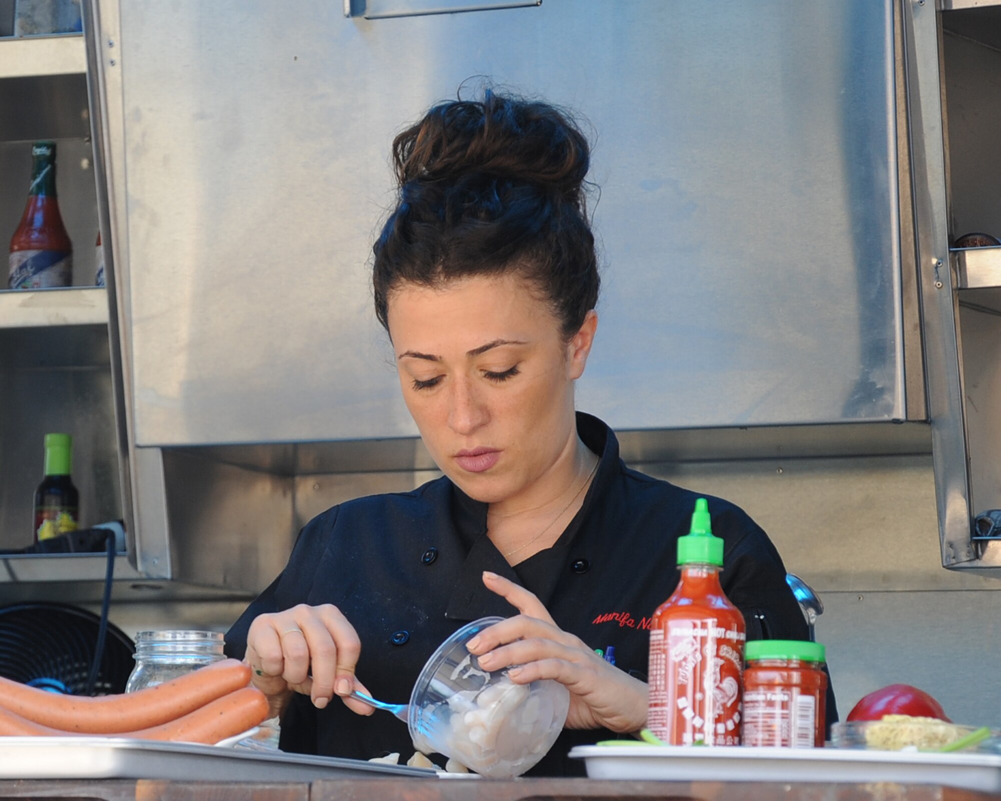 Manifa Nazarian, sous chef, prepares food during a taping of Flip My Food on Barksdale Air Force Base, La., July 9, 2014. Chef Jeff Henderson, Flip My Food host, takes traditional recipes and flips them into fresh, healthy dishes.  (U.S. Air Force photo/Staff Sgt. Sean Martin)

