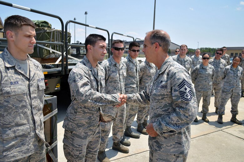 Chief Master Sgt. Pete Stone, U.S. Air Force Expeditionary Center command chief, presents his coin to Airman 1st Class Christopher Degen, 3rd Aerial Port Squadron, during his tour of 43rd Airlift Group units on July 8, 2014, Pope Army Airfield, N.C. (U.S. Air Force photo/Marvin Krause)