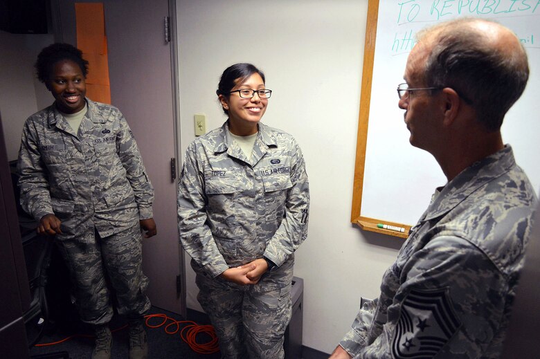 Chief Master Sgt. Pete Stone, U.S. Air Force Expeditionary Center command chief, discusses enlisted issues with Staff Sgt. Tanasha Smith, left, and Airman 1st Class Celeste Lopez, center, of the 43rd Force Support Squadron, during his tour of 43rd Airlift Group units on July 8, 2014, Pope Army Airfield, N.C. (U.S. Air Force photo/Marvin Krause)