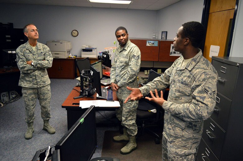Airman 1st Class Alio Naallah, right, and Staff Sgt. Dwayne Simeon, of the 43rd Comptroller Flight, discuss enlisted issues with Chief Master Sgt. Pete Stone, U.S. Air Force Expeditionary Center command chief, during his tour of 43rd Airlift Group units on July 8, 2014, Pope Army Airfield, N.C. Stone later presented his coin to Naallah for outstanding duty performance. (U.S. Air Force photo/Marvin Krause)