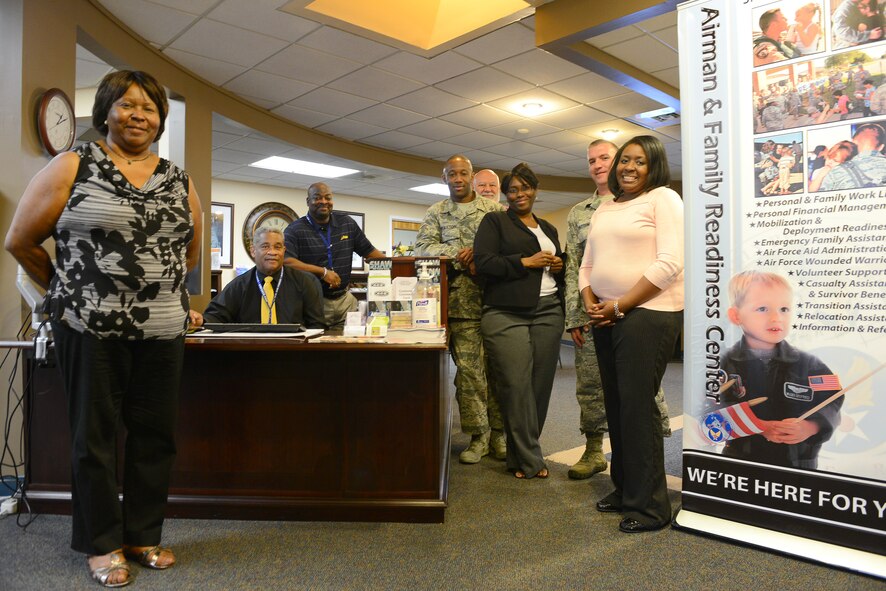The 20th Force Support Squadron Airman and Family Readiness Center community readiness consultants and specialists stand by the front desk in the A&FRC on Shaw Air Force Base, S.C., July 9, 2014. The A&FRC supports individuals, families, and leadership with programs and services to strengthen communities, encourage self-sufficiency, enhance mission readiness and ease adaptation to the Air Force way of life. (U.S. Air Force photo by Airman 1st Class Diana M. Cossaboom/Released)