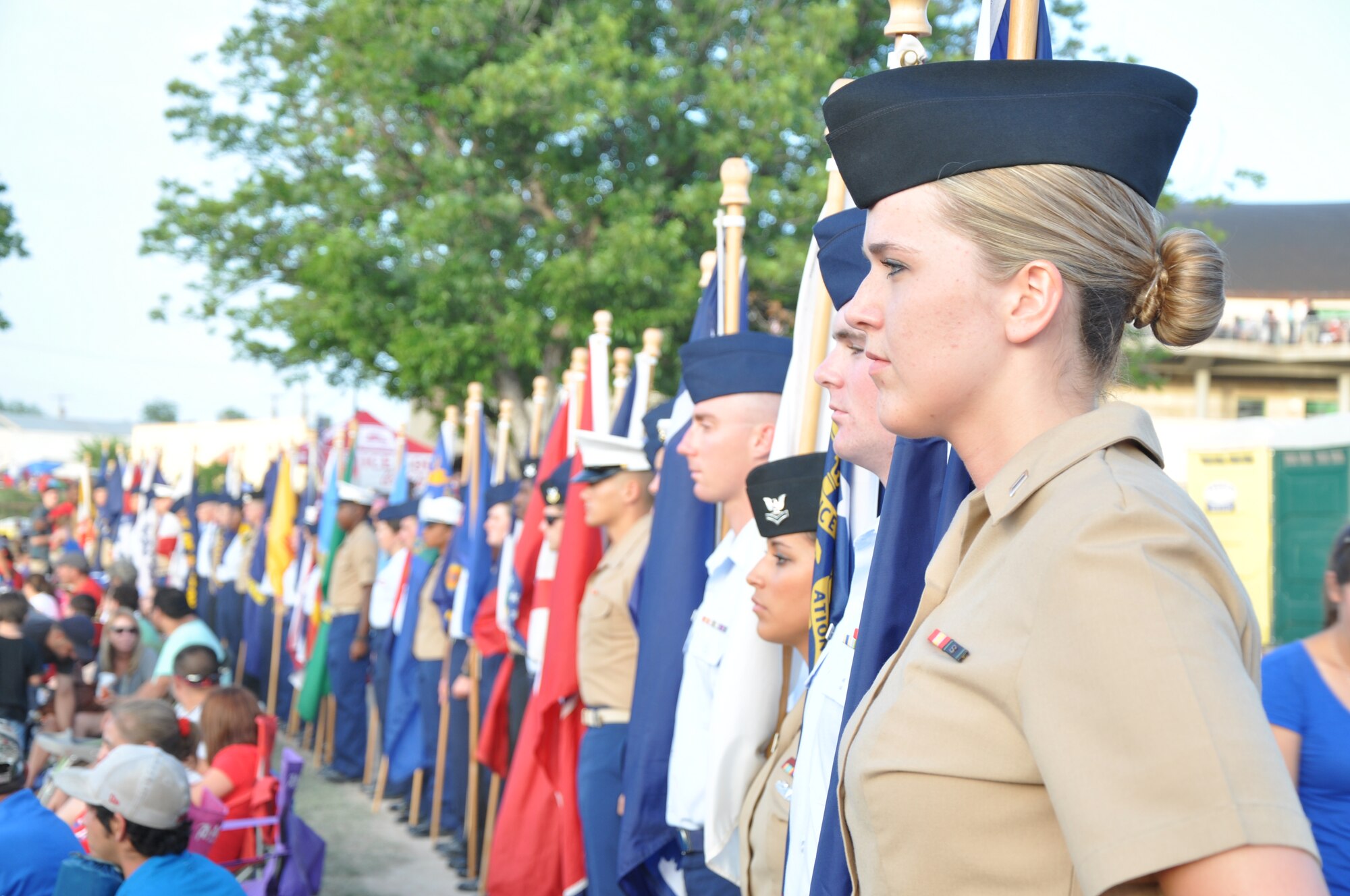 SAN ANGELO, Texas – Goodfellow volunteers line up with state flags for a review during the Annual Pops Concert at the Bill Aylor Sr. Memorial RiverStage here July 3. Goodfellow volunteers also assisted with seating, presenting the U.S. flag from the South Chadbourne Street Bridge and water canon firing. (U.S. Air Force photo/ Senior Airman Joshua Edwards)