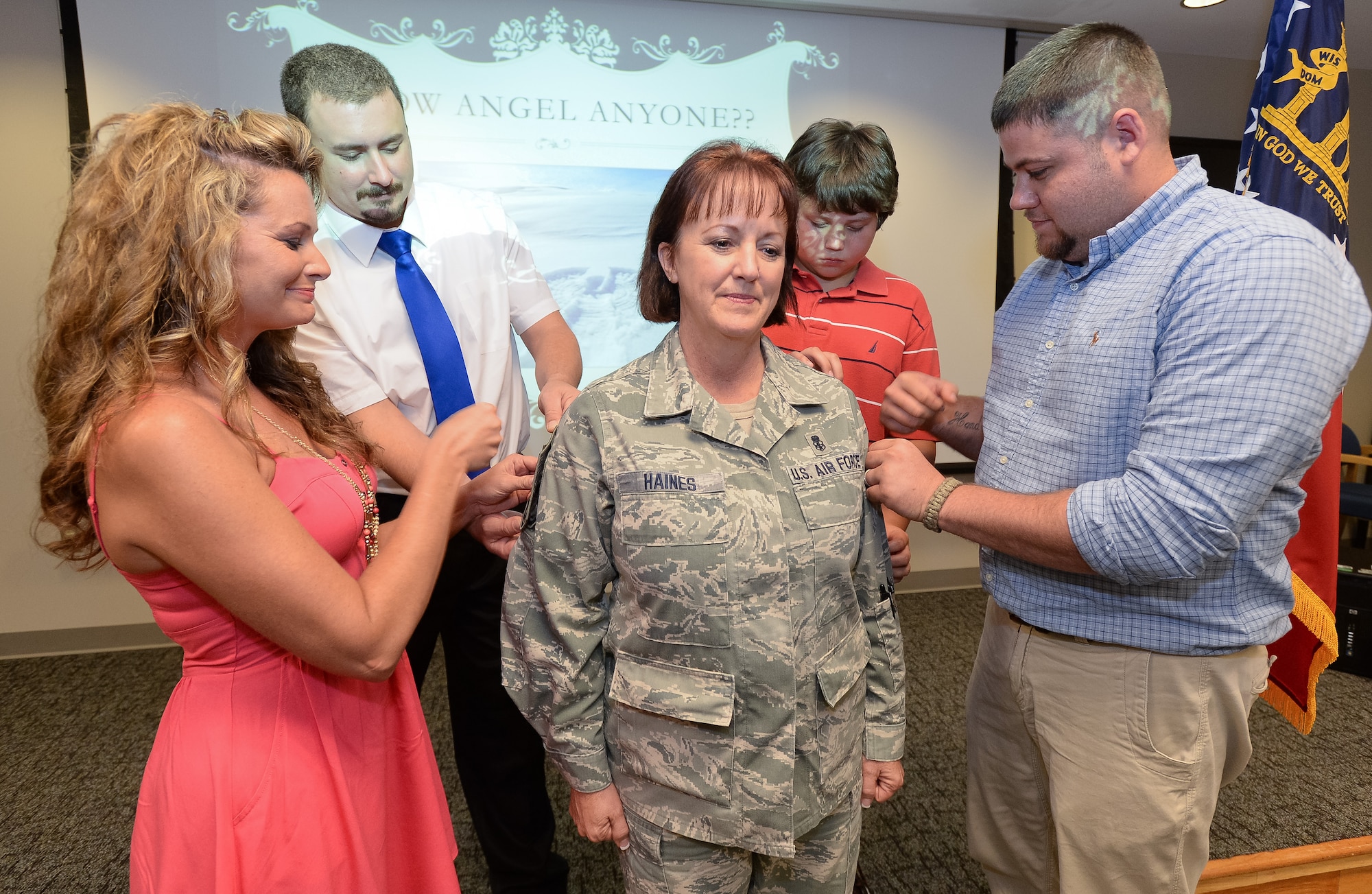 U.S. Air Force Chief Master Sgt. Cynthia Haines, 116th Medical Group (MDG) superintendent of nursing services,  Georgia Air National Guard, has her new stripes ceremonially pinned on by her family during her promotion ceremony, Robins Air Force Base, Ga., June 21, 2014. Haines became the first female to be promoted to Chief Master Sgt. in the history of the 116th MDG. The 116th MDG is the medical arm of the 116th Air Control Wing.  (U.S. Air National Guard photo by Master Sgt. Roger Parsons/Released)