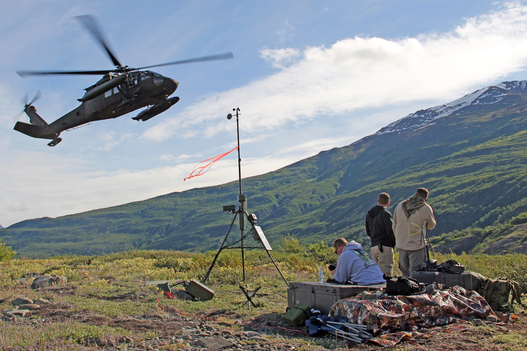 COLONY GLACIER, Alaska -- A UH-60 Black Hawk helicopter from the Alaska Army National Guard delivers supplies to the 3rd Operations Support Squadron Weather Flight personnel near Colony Glacier June 18. The weather flight provided vital real-time weather data to aircrew in support of Operation Colony Glacier. The real-time weather data is crucial for aircrew and aircraft safety because weather near glaciers change rapidly and are dangerous. (Photo by Tech. Sgt. Heinz Disch)