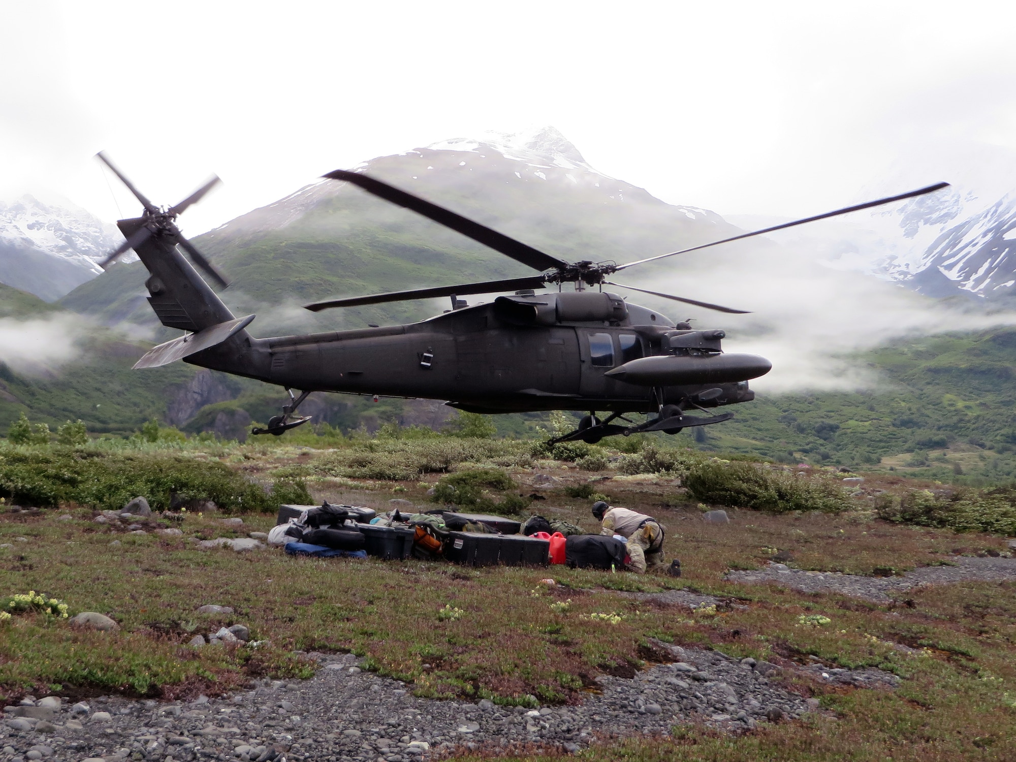 COLONY GLACIER, Alaska -- A UH-60 Black Hawk helicopter from the Alaska Army National Guard drops off the 3rd Operations Support Squadron Weather Flight personnel and their gear near Colony Glacier June 17. The weather flight provided vital real-time weather data to aircrew in support of Operation Colony Glacier. The real-time weather data is crucial for aircrew and aircraft safety because weather near glaciers change rapidly and are dangerous. (Photo by Tech. Sgt. Heinz Disch)
