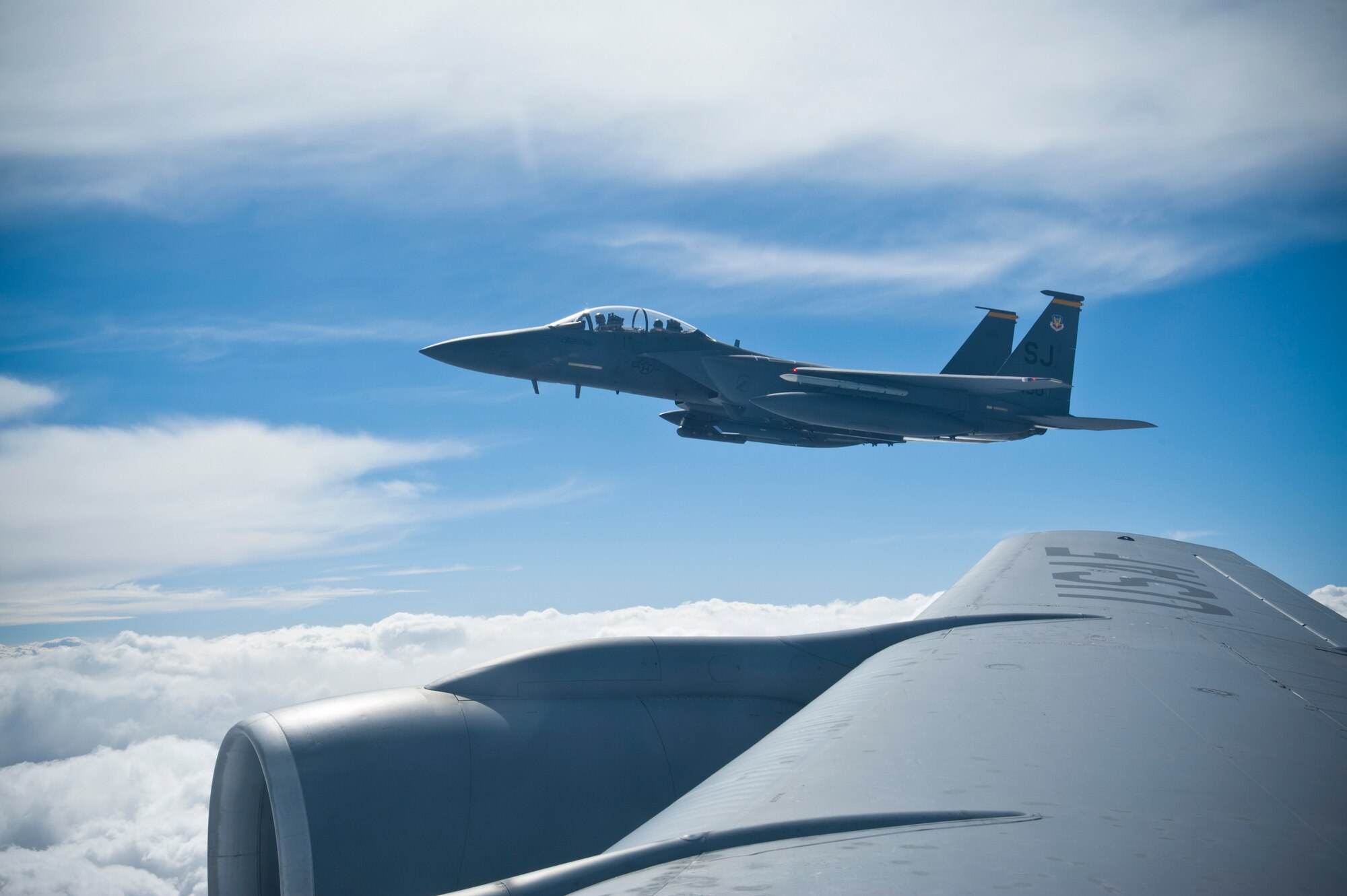 An F-15E Strike Eagle flies alongside a KC-135 Stratotanker while waiting for its wingman to finish refueling during Red Flag 14-2 on March 13, 2014, over the Nevada Test and Training Range. Red Flag provides different units, military branches and countries the opportunity to train together in a realistic combat scenario. (U.S. Air Force photo by Airman 1st Class Timothy Young)