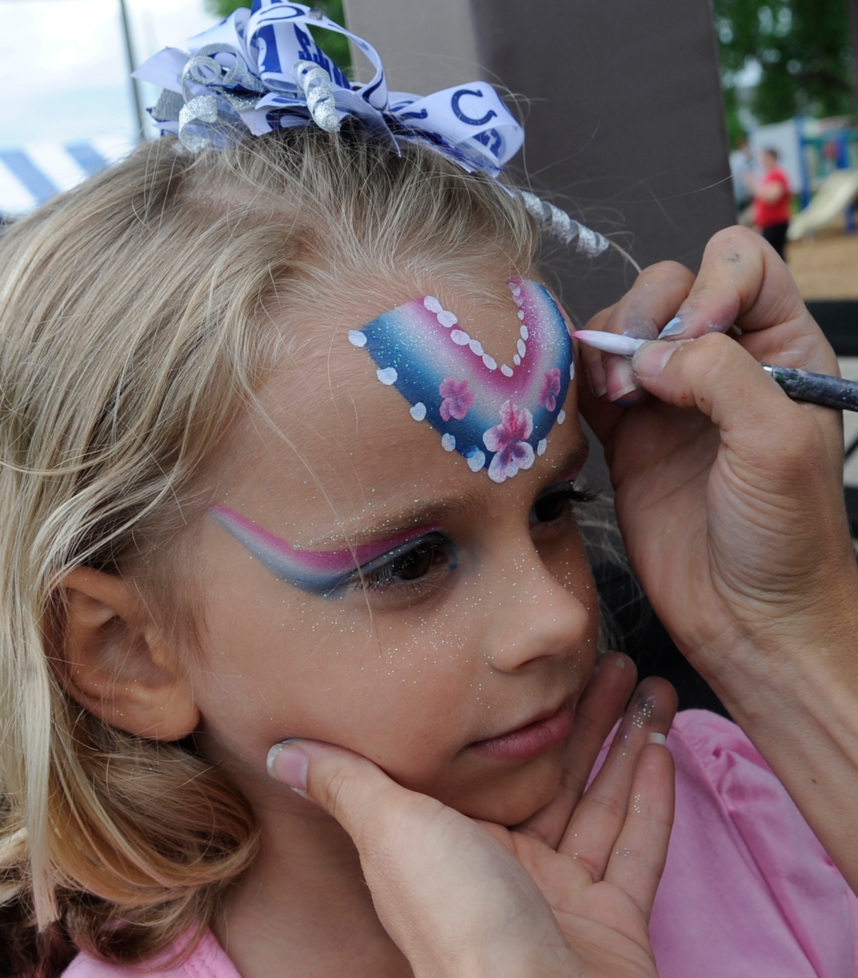 Isabella gets her face painted at the Independence Day Celebration at Whiteman Air Force Base, Mo., July 2, 2014. Food, drinks and family activities were provided before the fireworks.  She is the daughter of Tech. Sgt. Zach Linton, 509th Security Forces Squadron, assistant NCOIC training supervisor. (U.S. Air Force photo by Staff Sgt. Alexandra M. Boutte/Released)