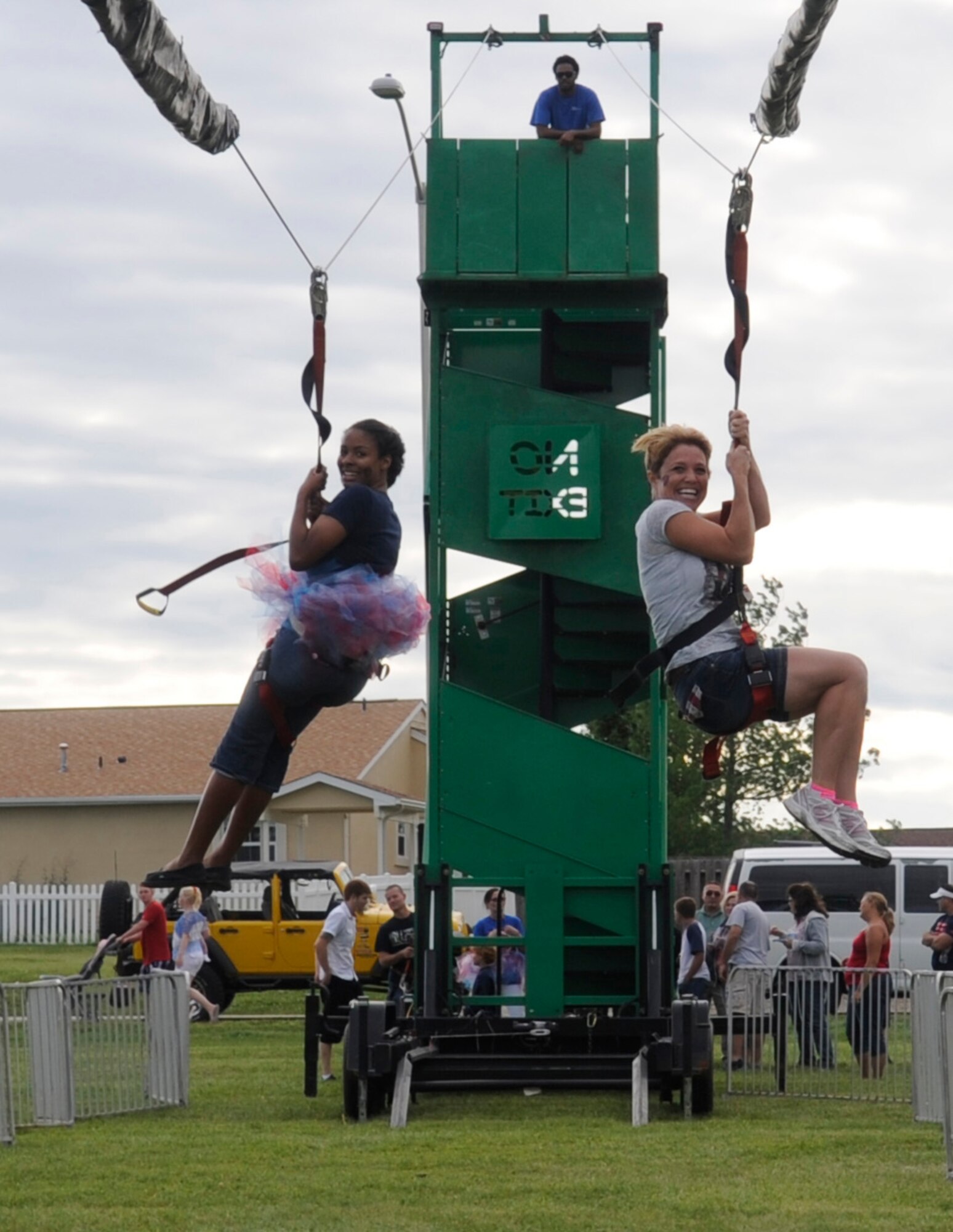 Trinicia Kloepper and Tiffany Kalin slide down the zip line at the Independence Day Celebration at Ike Skelton Lake on Whiteman Air Force Base, Mo., July 2, 2014. Trinicia is the wife of Capt. Bryan Kloepper, 509th Maintenance Group Operations Commander, and Tiffany is the wife of Maj Jason Kalin, 509th Logistics Readiness Squadron. (U.S. Air Force photo by Staff Sgt. Alexandra M. Boutte/Released)