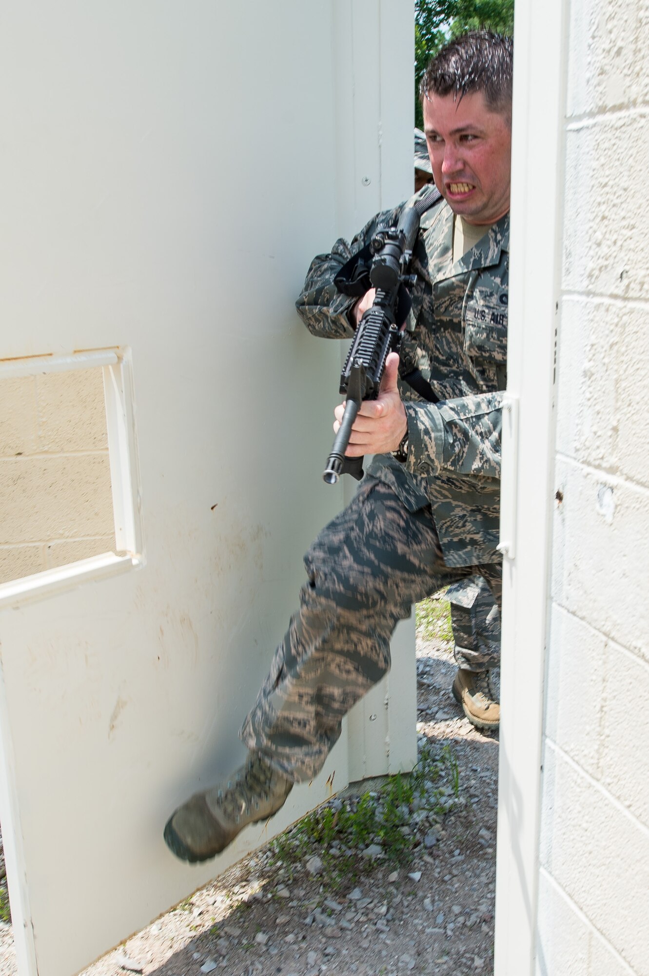 U.S Air Force Staff Sgt. Sean Reed, a member of the 116th Security Forces Squadron, Georgia Air National Guard, breaches a building during training at the Catoosa Training Site, Tunnel Hill, Ga., June 27, 2014. The squadron deployed to the Catoosa Training Site for annual training where they received extensive classroom and hands-on training to hone their skills on various firearms such as the M4 carbine, M203 grenade launcher and M240 and M249 machine guns as well as training in various security operations performed by Air Force security forces personnel. (U.S. Air National Guard photo by Master Sgt. Roger Parsons/Released)