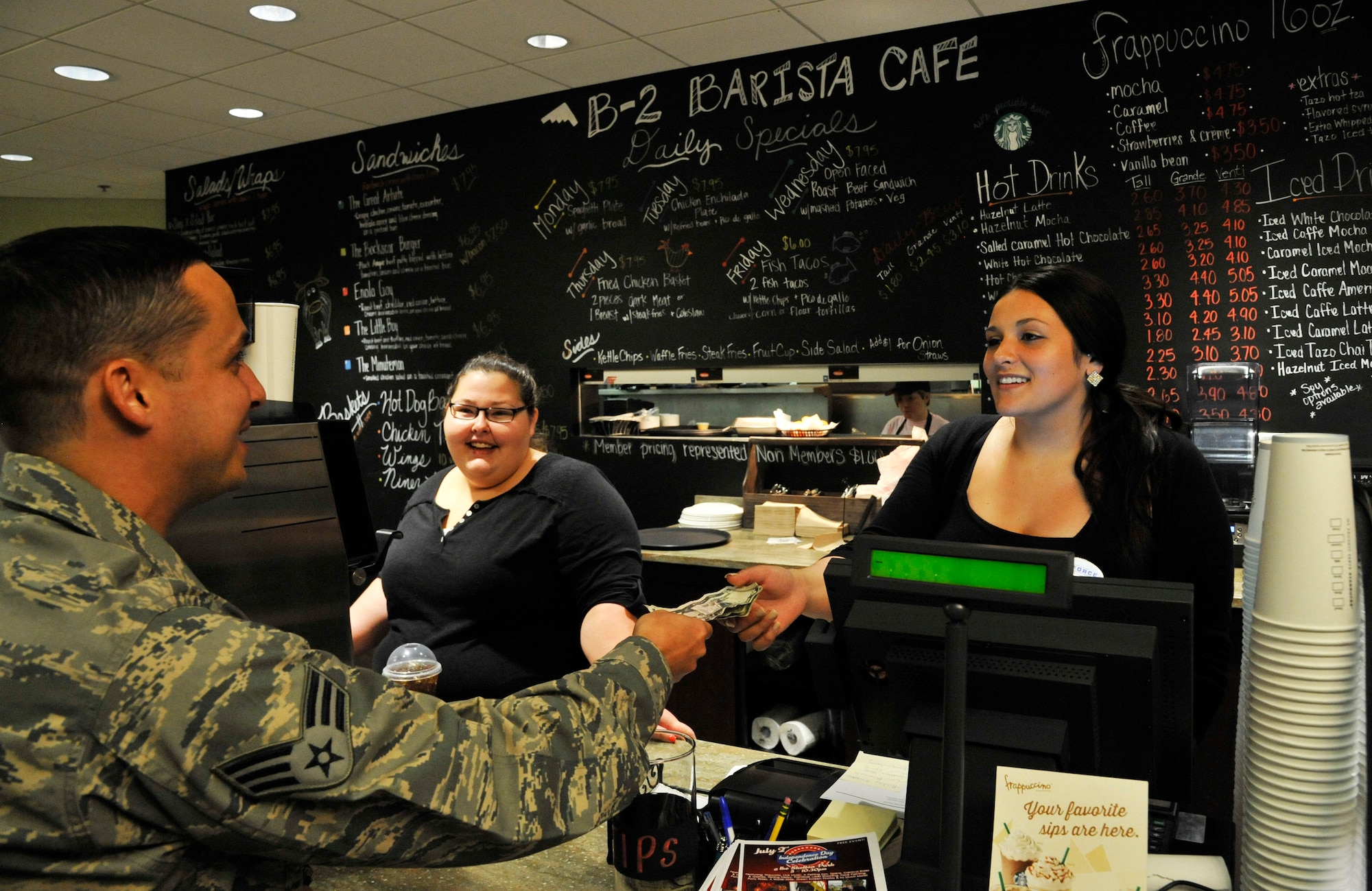 A customer pays Natalie Karagianis, 509th Force Support Squadron cashier, for his meal at the B-2 Barista Café on Whiteman Air Force Base, Mo., July 1, 2014. The café opens from 11 a.m. to 1 p.m., Monday- to Friday. (U.S. Air Force photo by Airman 1st Class Keenan Berry/Released)