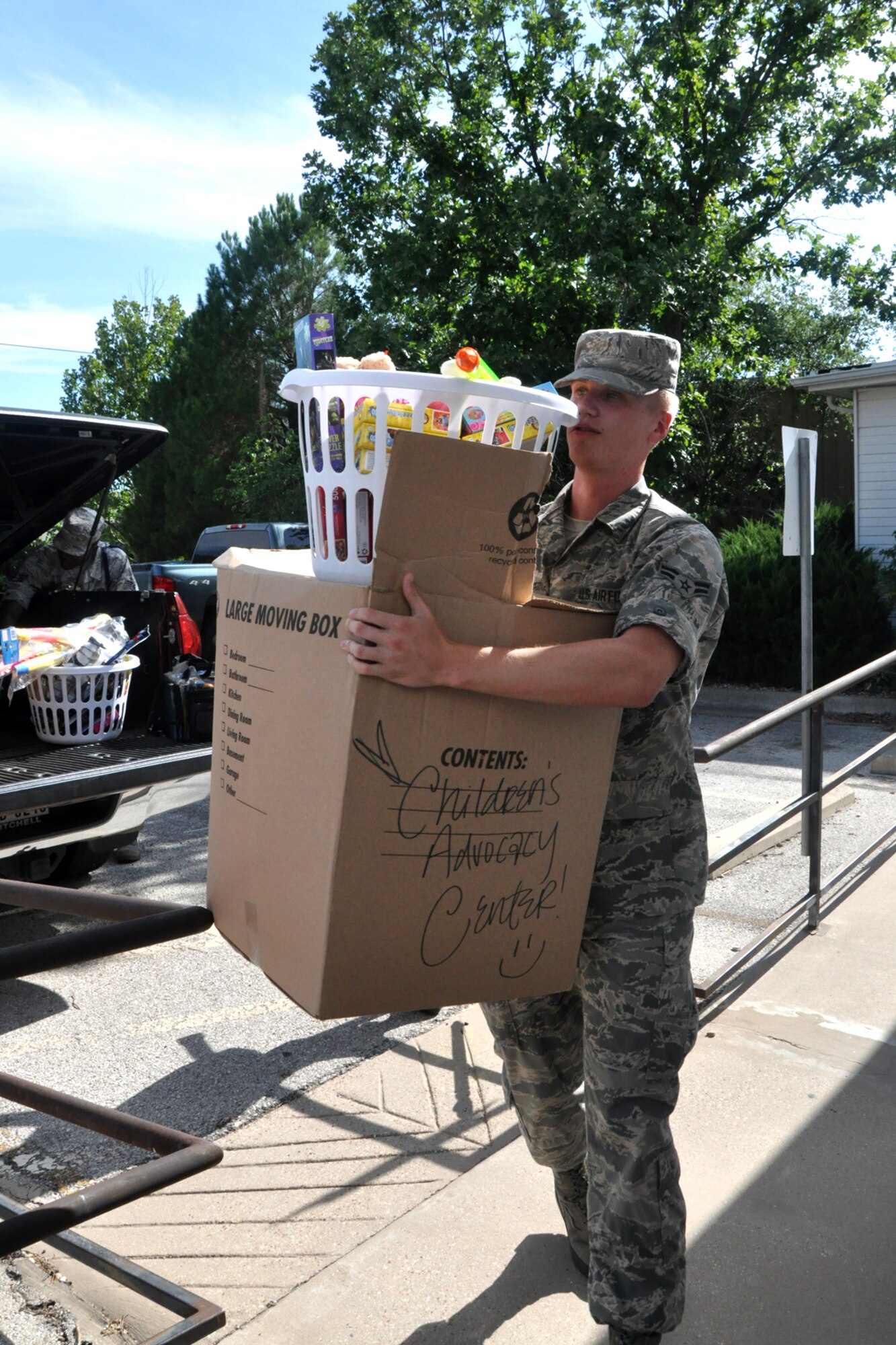SAN ANGELO, Texas – Airman 1st Class Jesse Rolle, 315th Training Squadron student, carries a box and basket filled with toys, books and other items into the Children’s Advocacy Center of Tom Green County during a donation drop-off July 1. Volunteers from the 315th TRS competed against each other to donate the most items. (U.S. Air Force photo/ Airman 1st Class Breonna Veal)